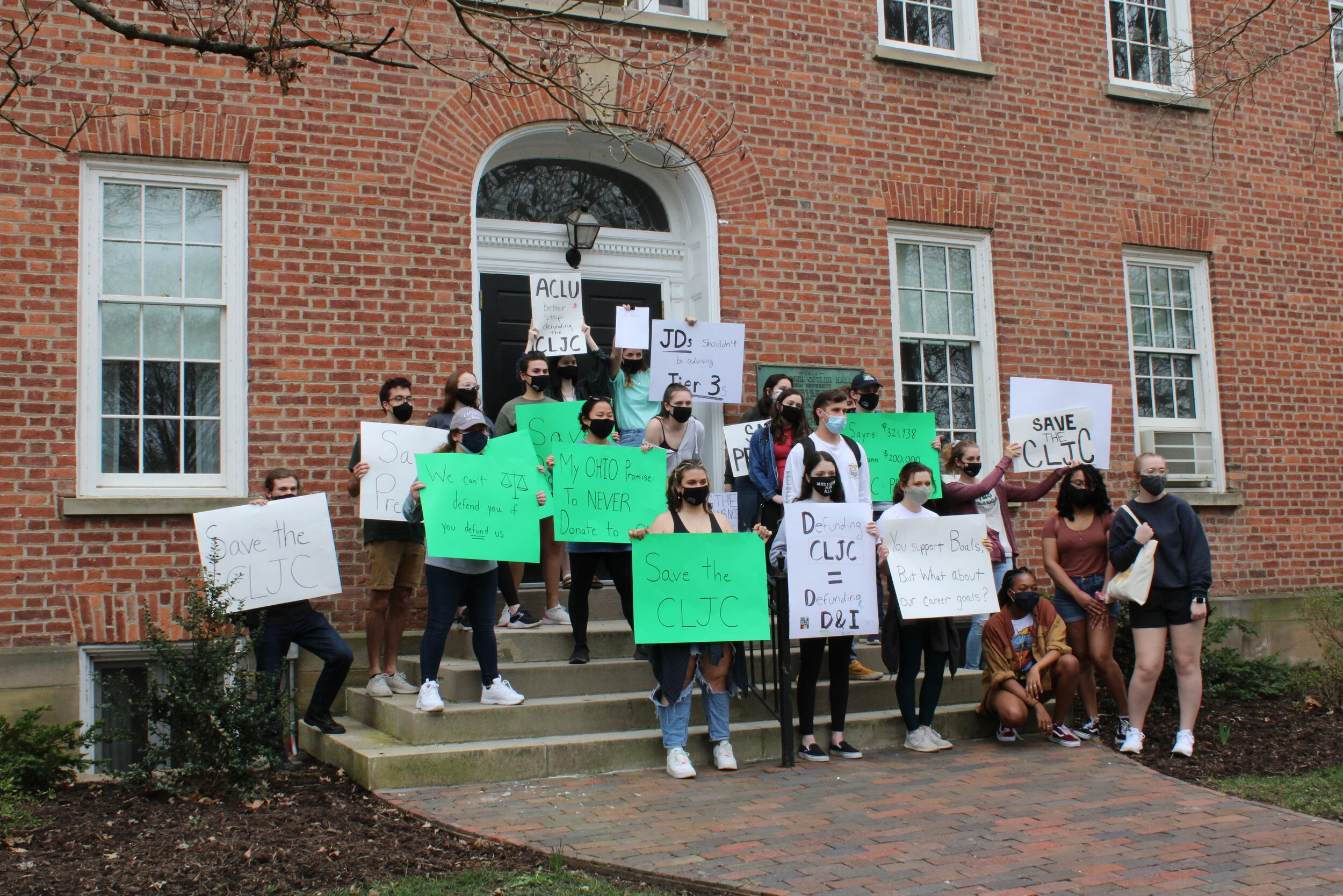    Students leave signs from the rally and a petition on the steps of Cutler Hall.&nbsp;Photo by Emily Crebs.   