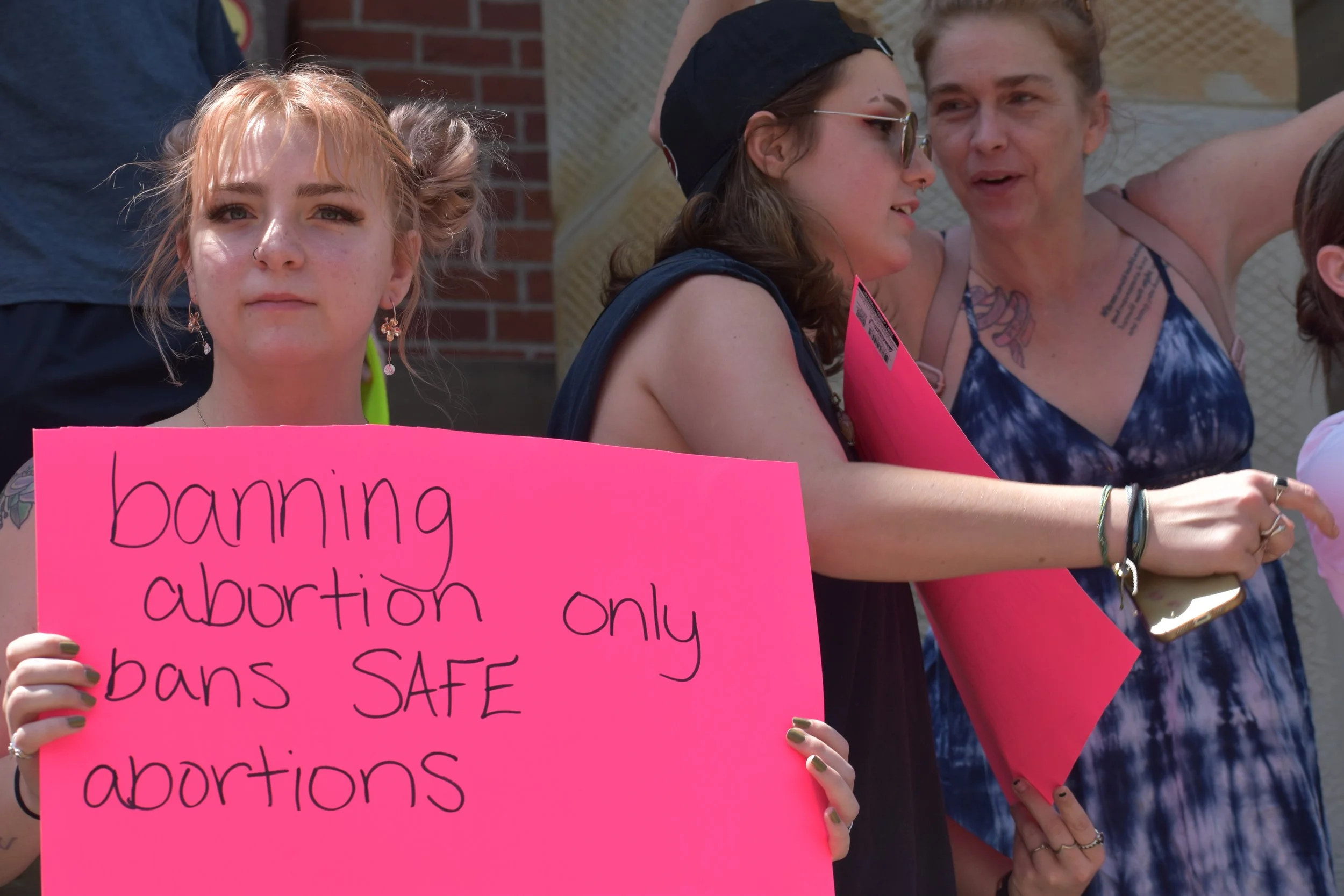  Protestors stand on the steps of the Athens County Courthouse. Photo by Bo Kuhn. 