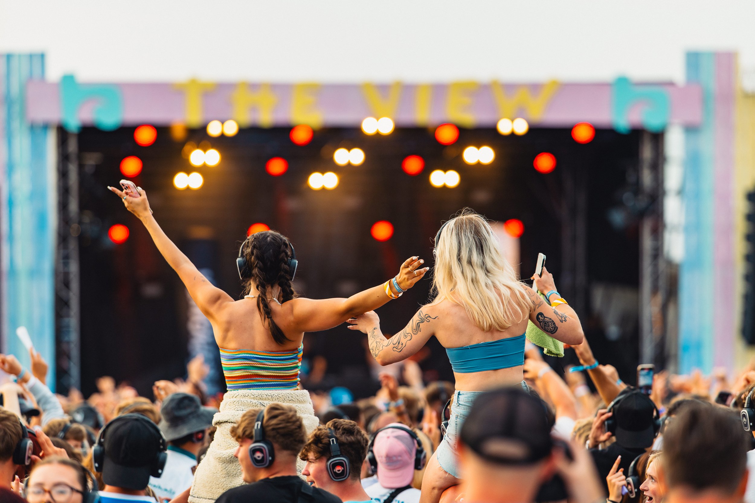 Festival goers on shoulders enjoying the music and cornish sun. Events photographer