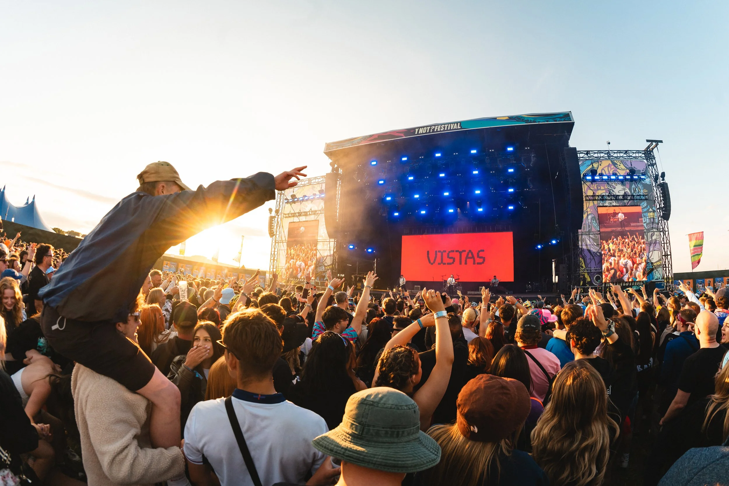 sun syining during golden hour at a uk music festival.