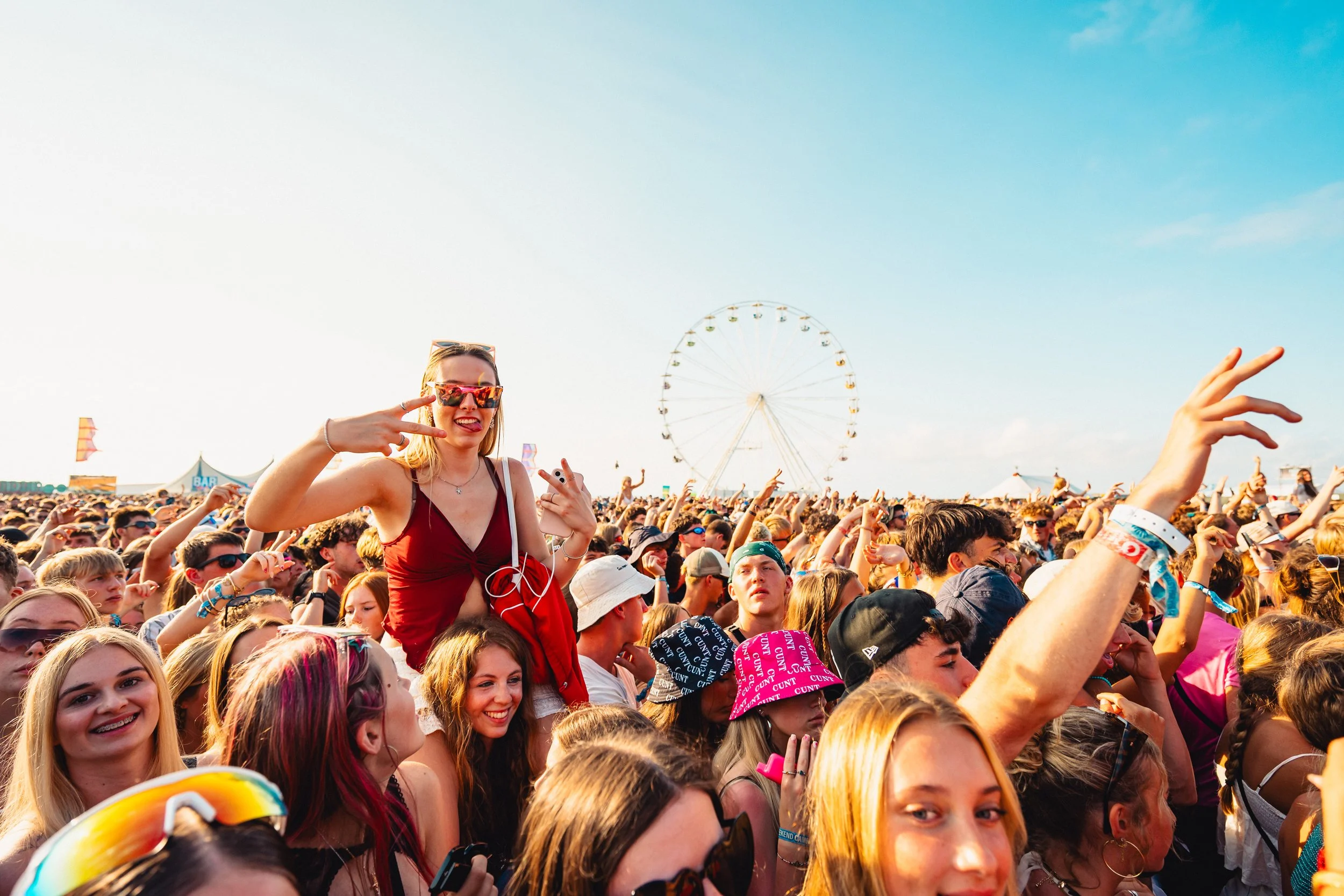 Girl on shoulders in the crowd at a uk festival. UK Music festival photographer.