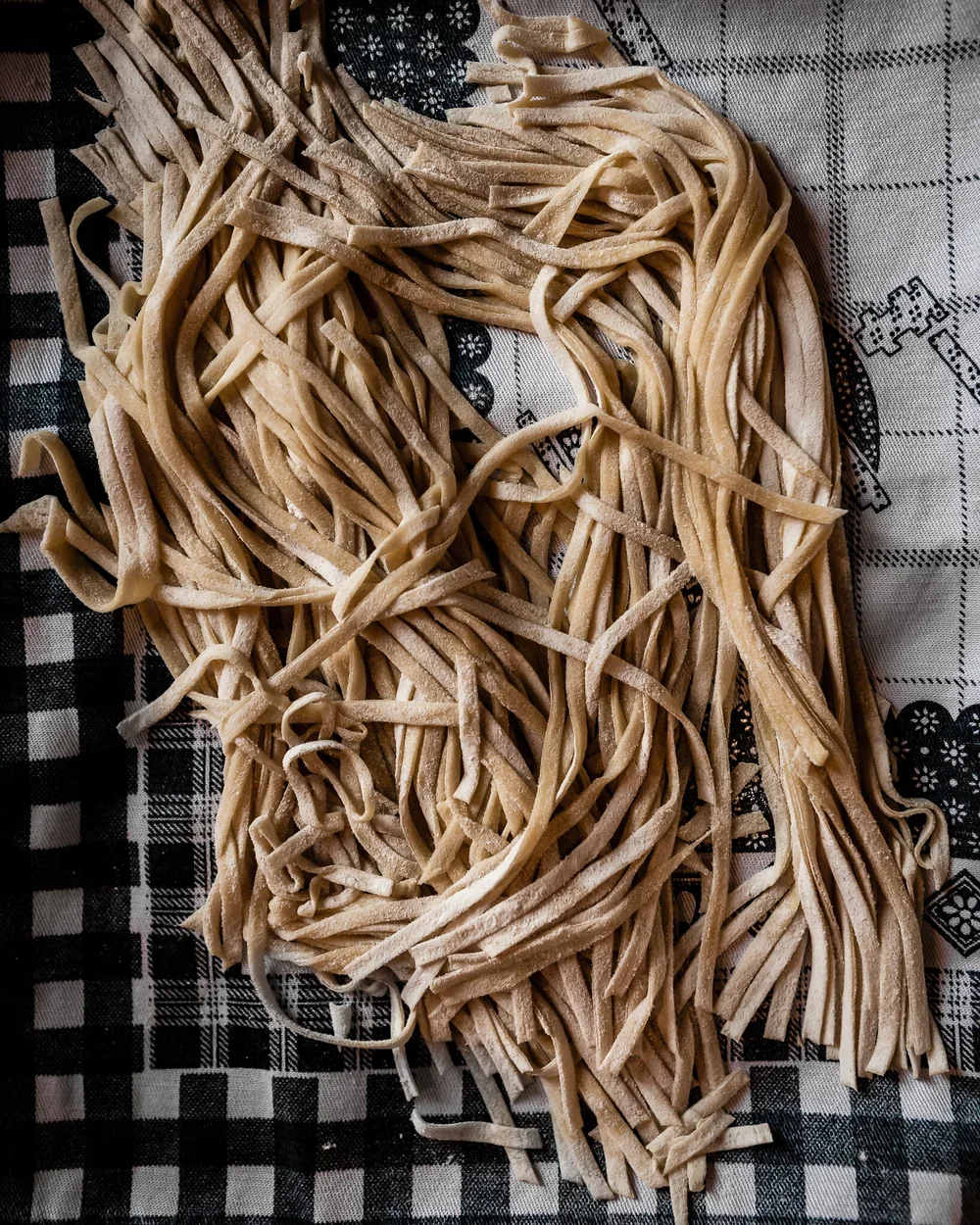 handmade pasta laying on a tea towel 
