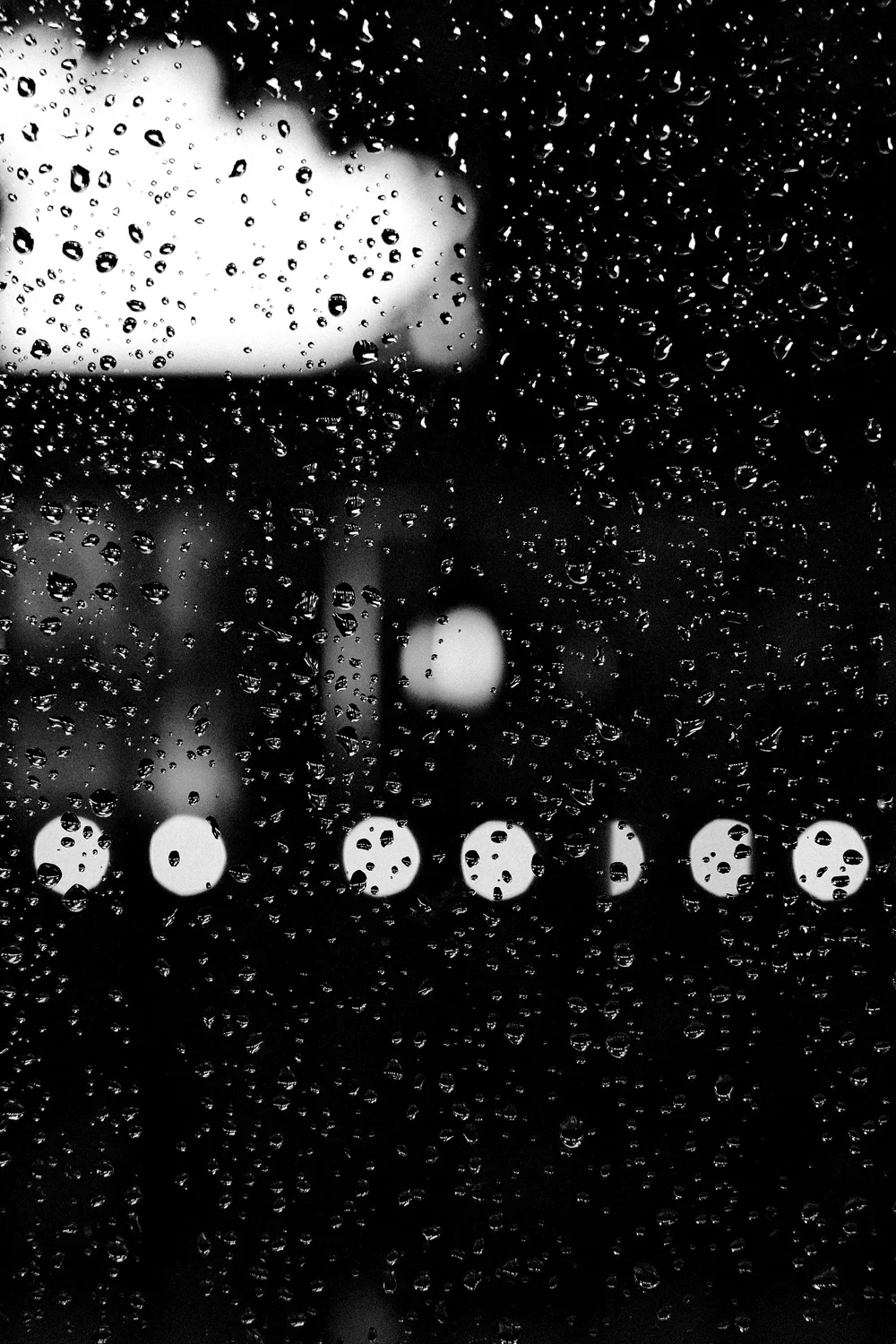 abstract double exposure image featuring black and white shapes that look like rain falling from a cloud.