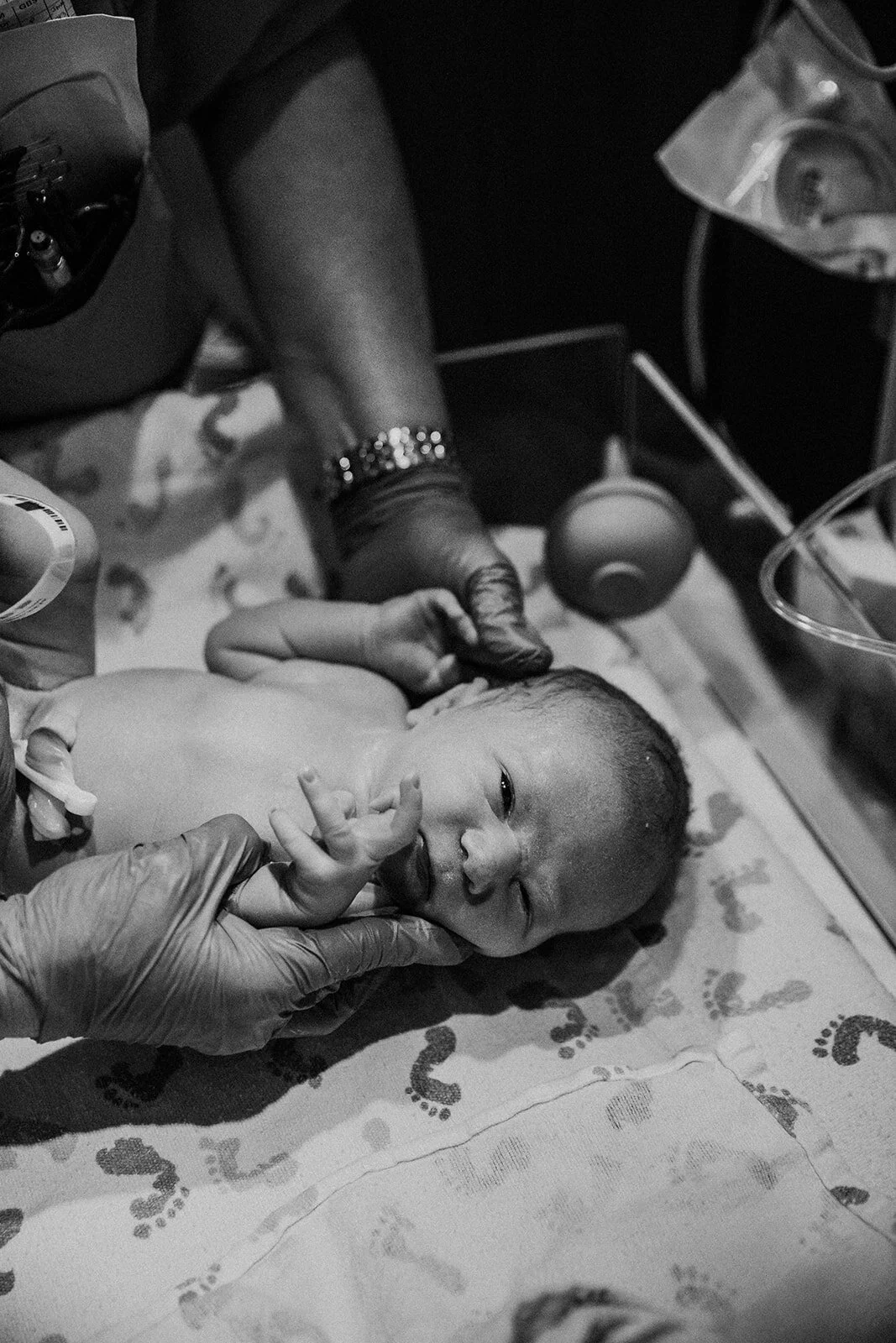 a newborn undergoes the newborn exam immediately following birth | black and white birth photography