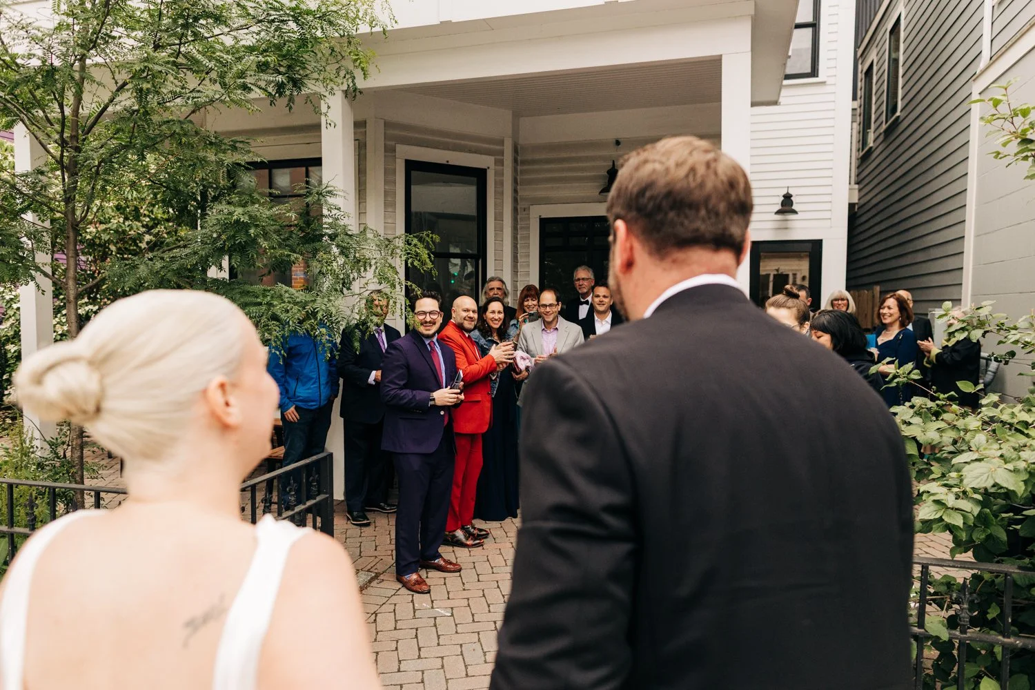 Friends react to a couple's arrival at their small wedding at Juliet in Somerville, Massachusetts.