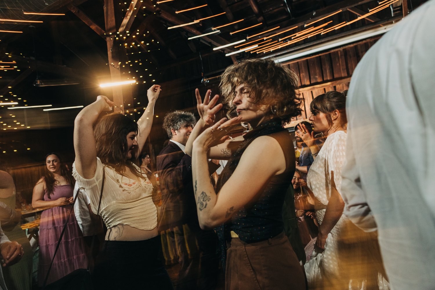 guests dance during a wedding reception at the red barn at hampshire college in amherst, massachusetts