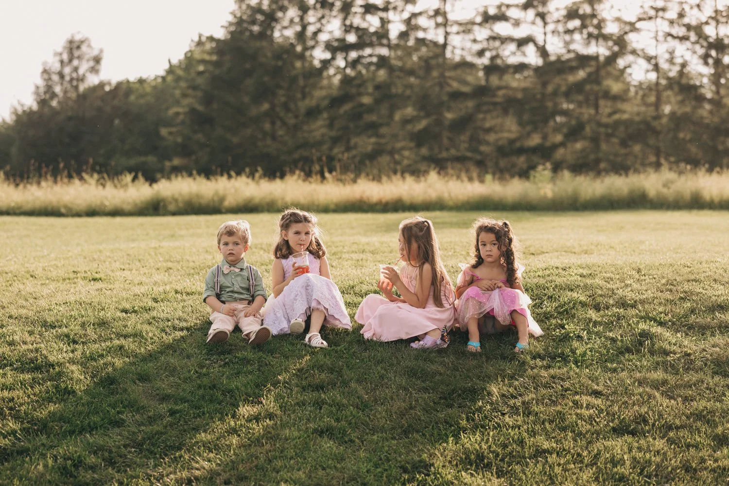 wedding guests sit on a hillside during a wedding reception at the red barn at hampshire college in amherst, massachusetts