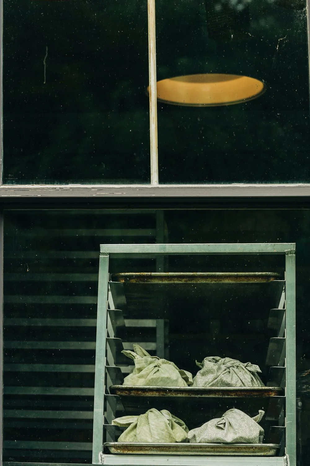 Baked bread is photographed through a window during a wedding at western massachusetts wedding venue Gloriosa & Co in Ashfield, Massachusetts.