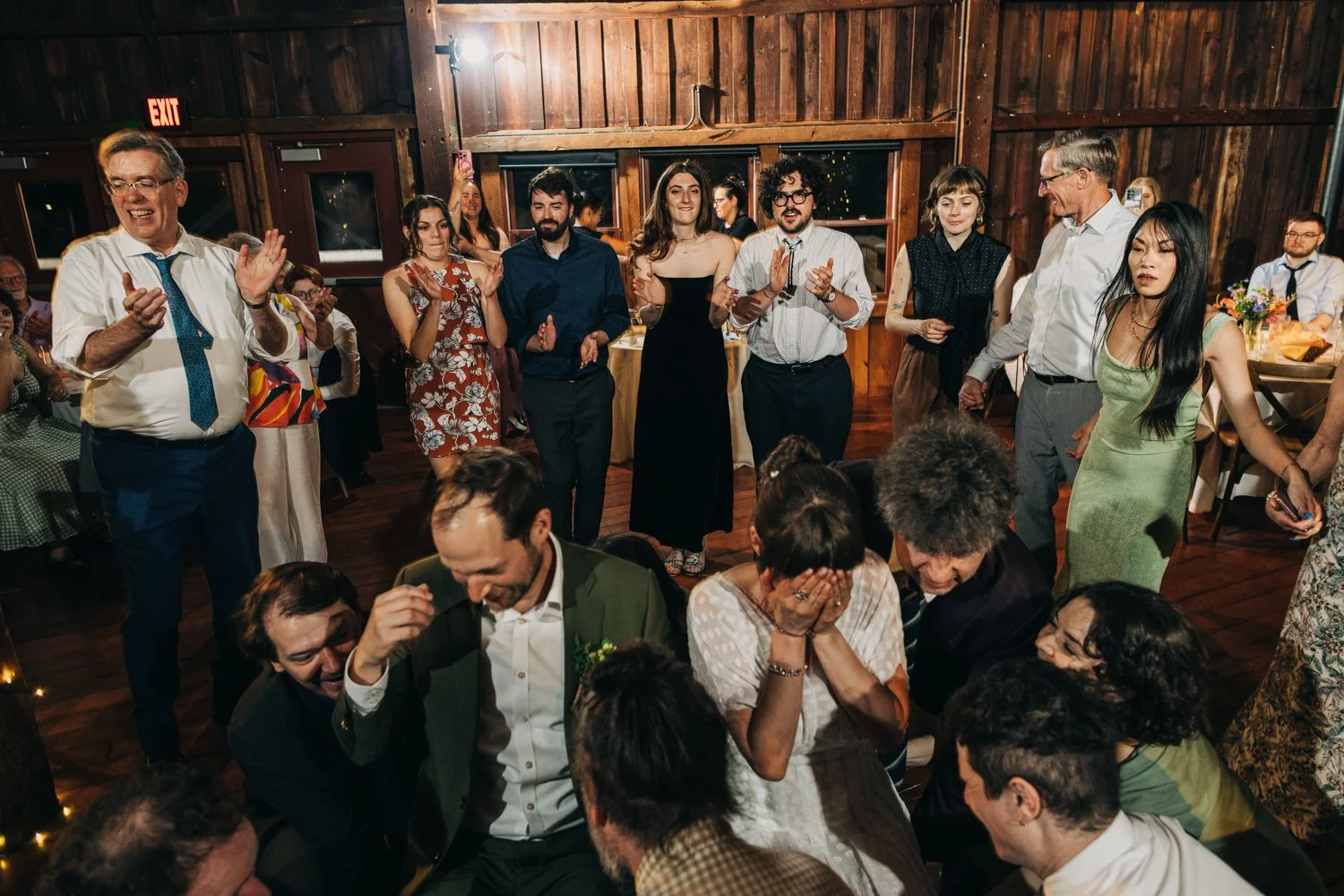 A bride and groom prepare to be lifted in chairs during their wedding reception at the red barn at hampshire college in amherst, massachusetts