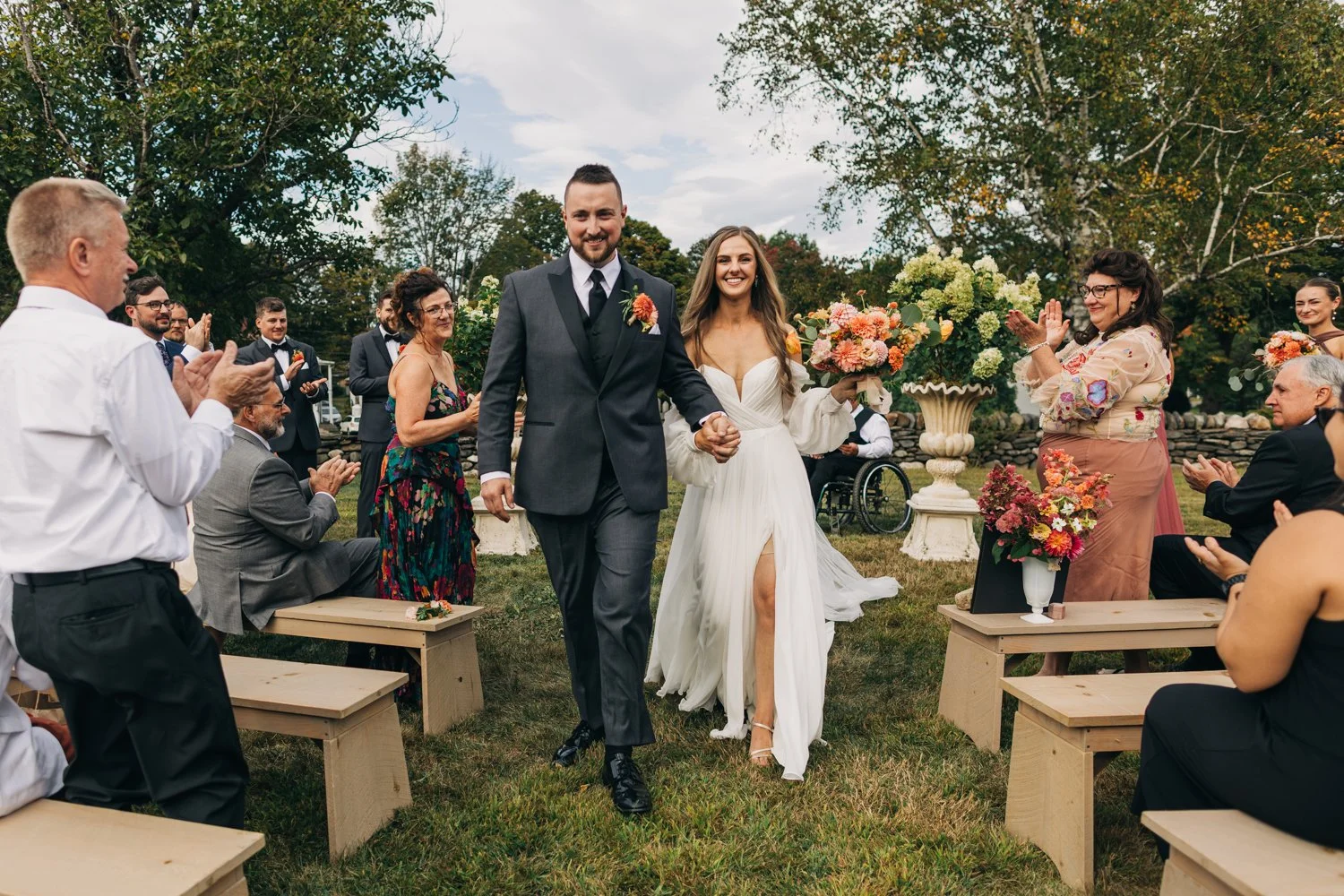 A bride and groom walk hand and hand out of their ceremony during a wedding at western massachusetts wedding venue Gloriosa & Co in Ashfield, Massachusetts.