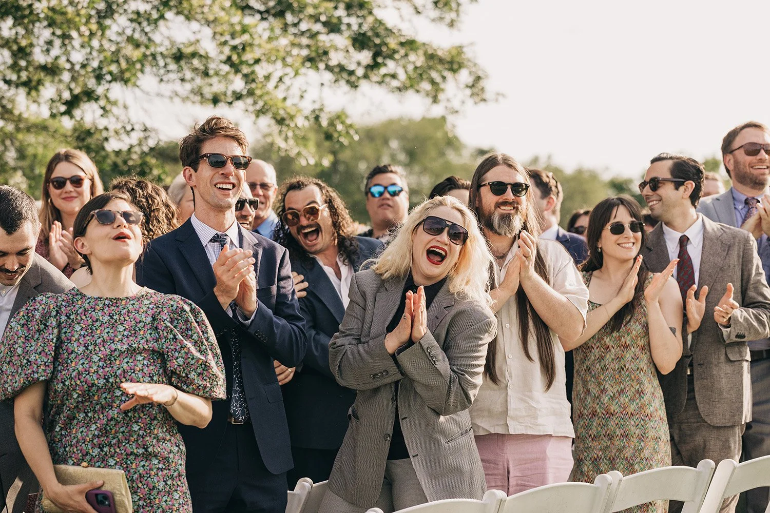 guests cheer for their friends as they walk down the aisle to their wedding ceremony at the red barn at hampshire college in amherst, massachusetts