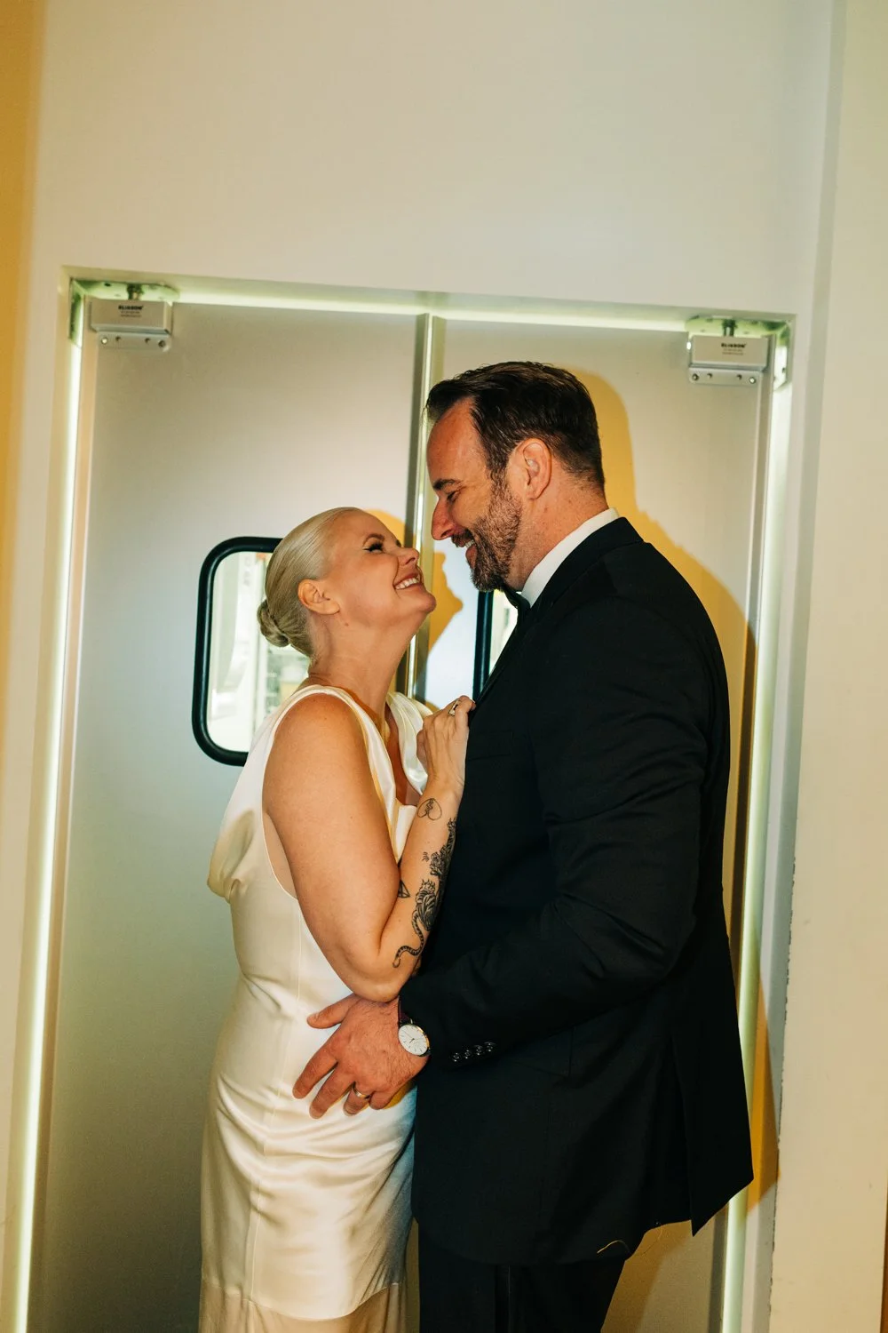 A bride and groom embrace near the door to the kitchen at Juliet in Somerville.