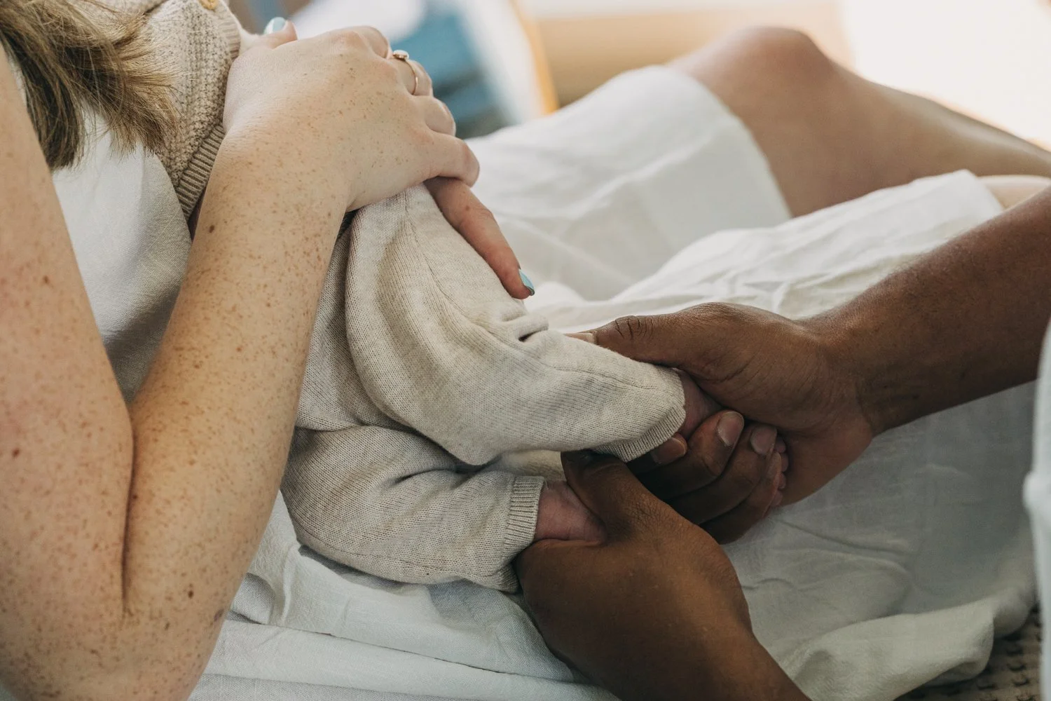 A newborn baby is held by his parents during a newborn photography session in western massachusetts.