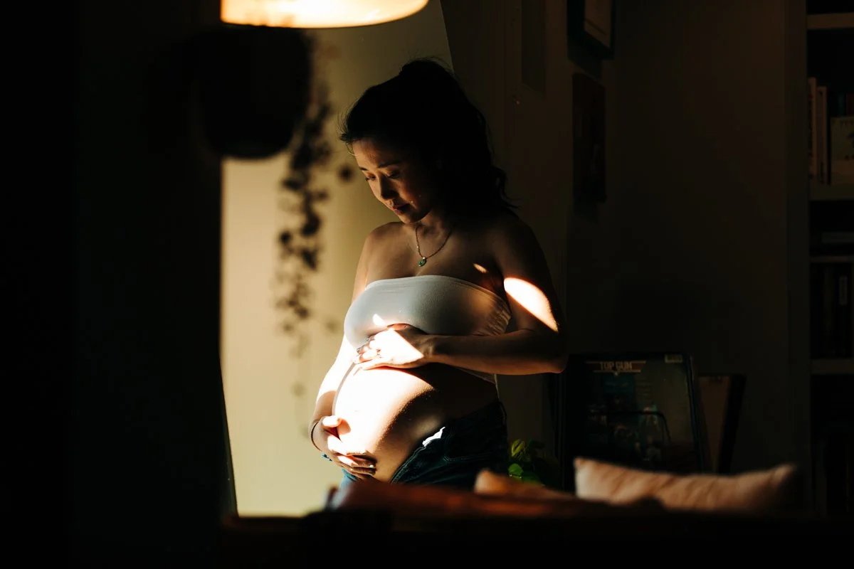 A pregnant woman poses for a maternity portrait in her apartment in Boston