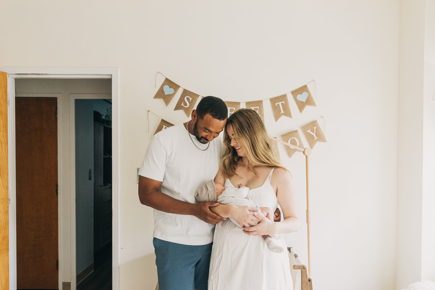 A couple holds their newborn baby in their nursery during a newborn photography session in western massachusetts.