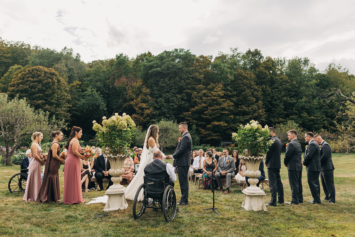 A bride and groom stand together in front of their family and friends during their wedding at western massachusetts wedding venue gloriosa and co