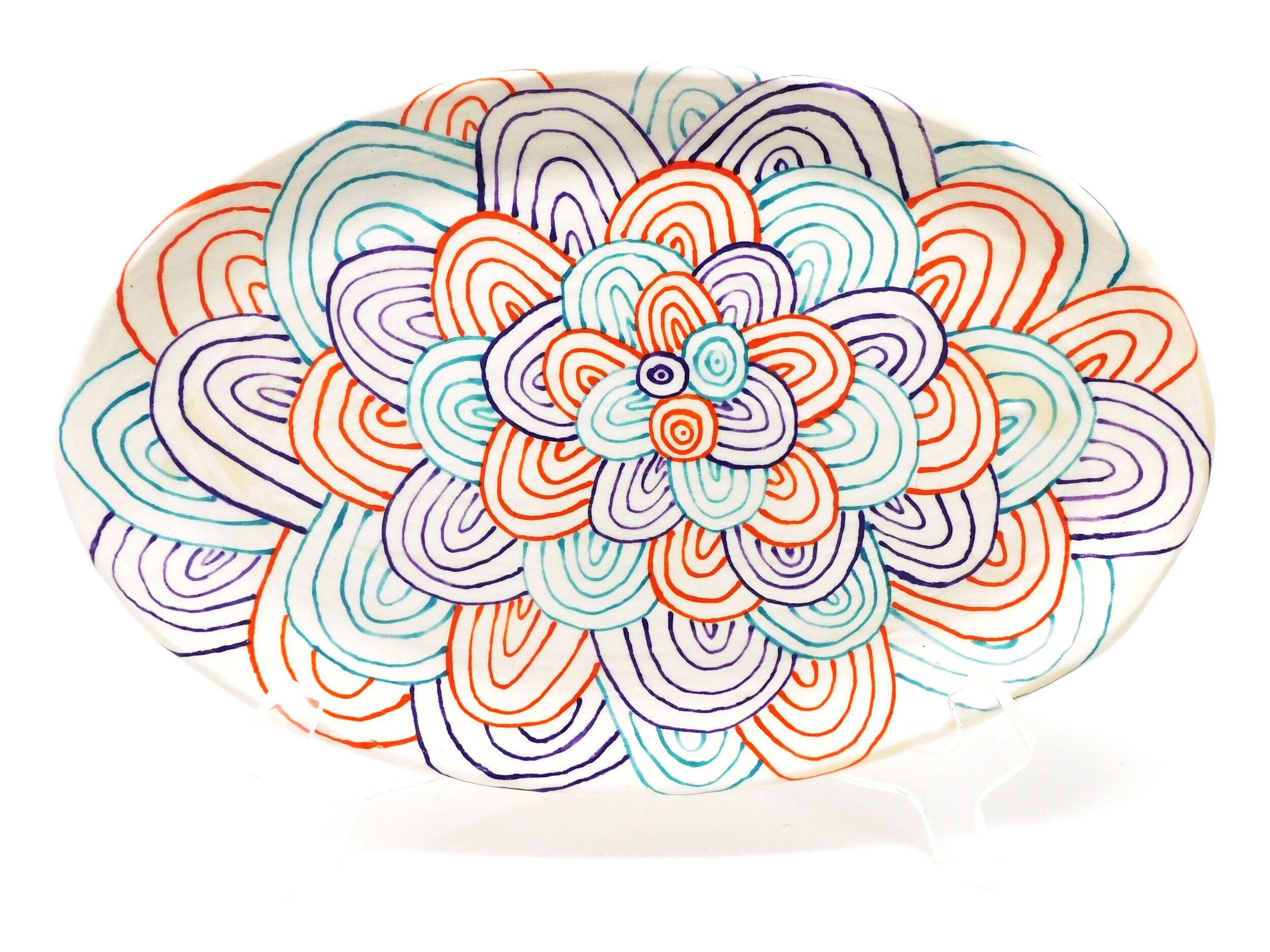Colorful abstract pattern with overlapping, concentric teardrop shapes in orange, purple, and teal on a white background ceramic plate.