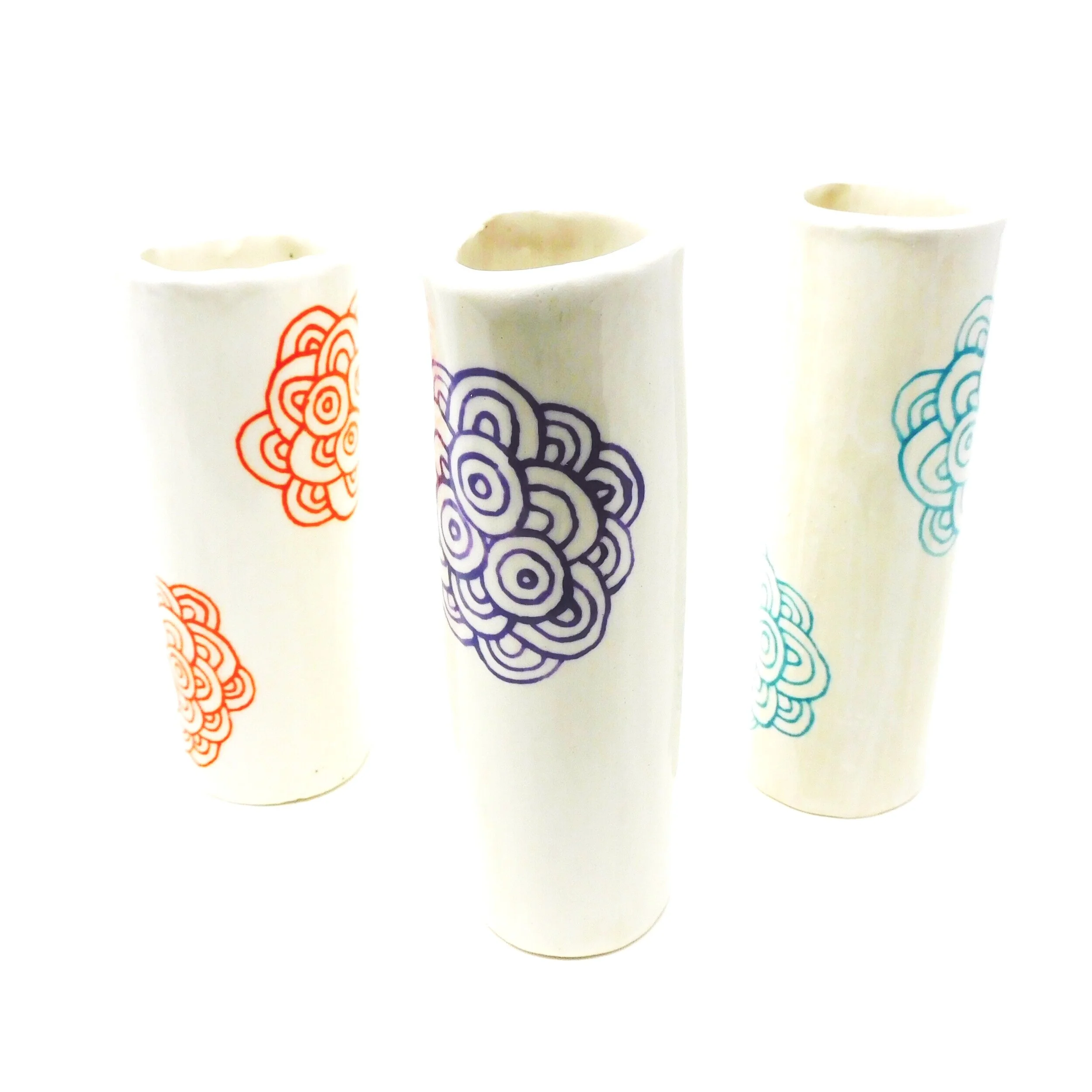 Three white cups with colorful floral designs.