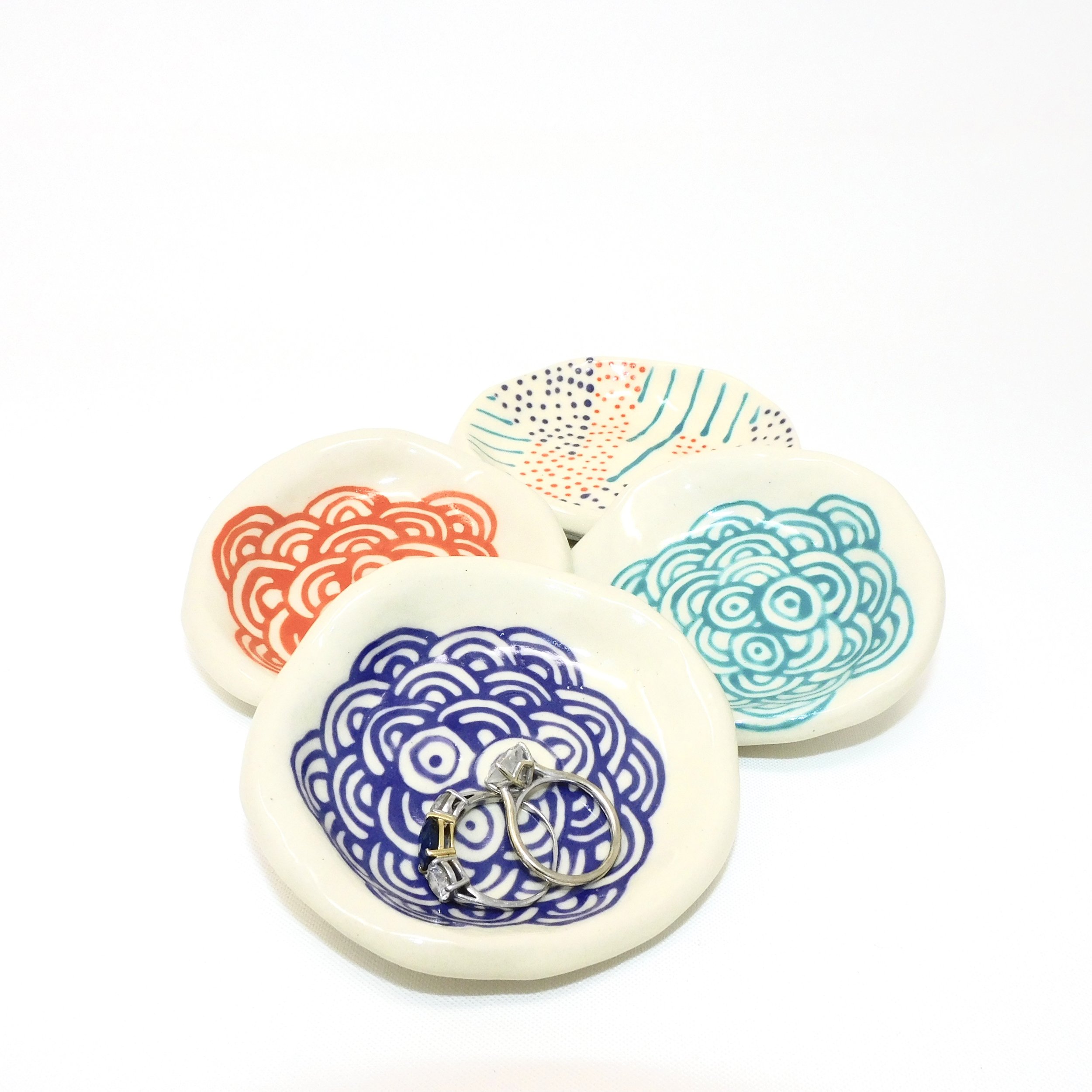 Colorful ceramic bowls with orange, purple, and teal design, arranged in a cluster.