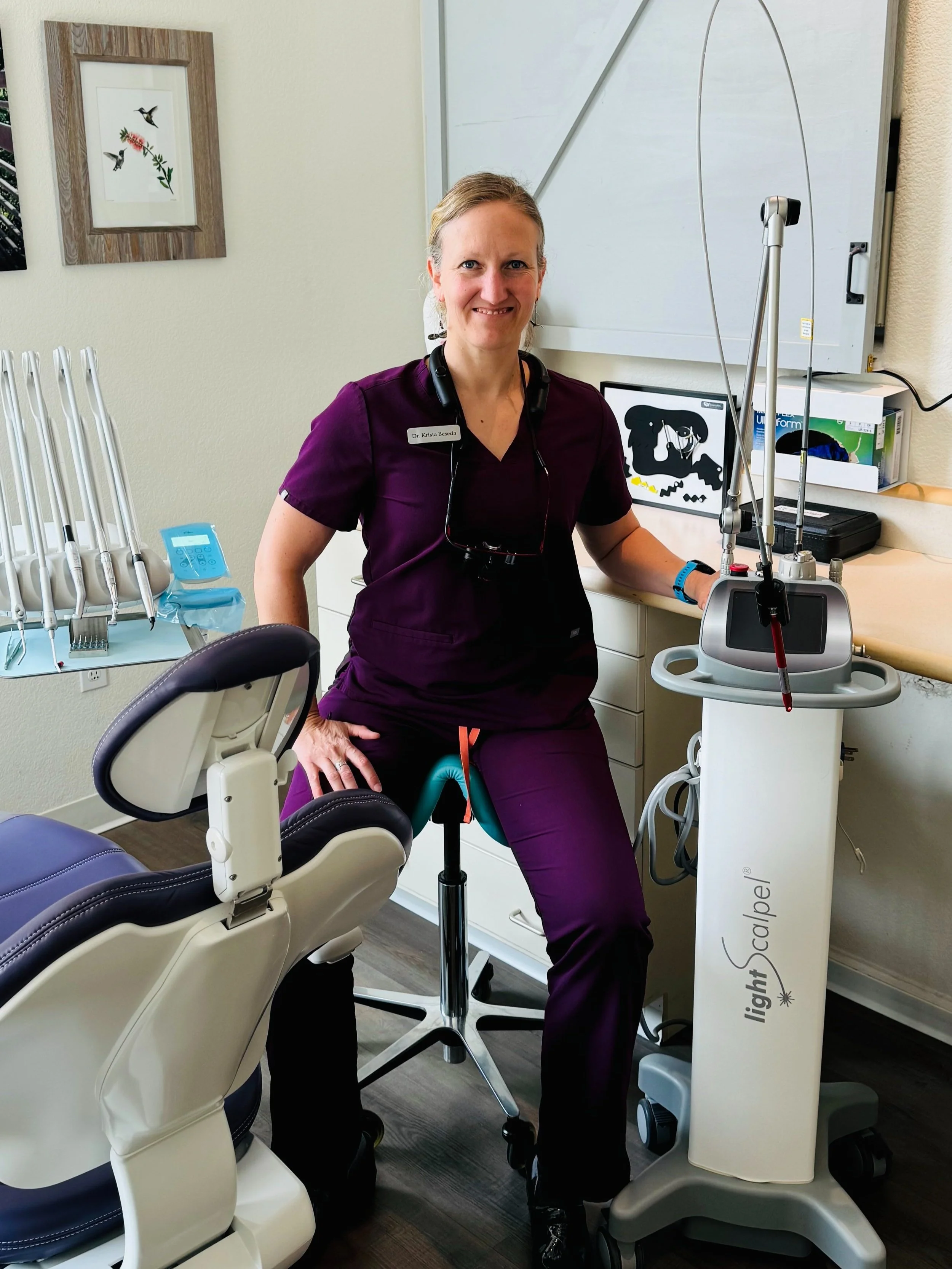 Close-up of a dental professional explaining a tongue tie procedure in Boulder to a patient during a consultation at a modern dental clinic.