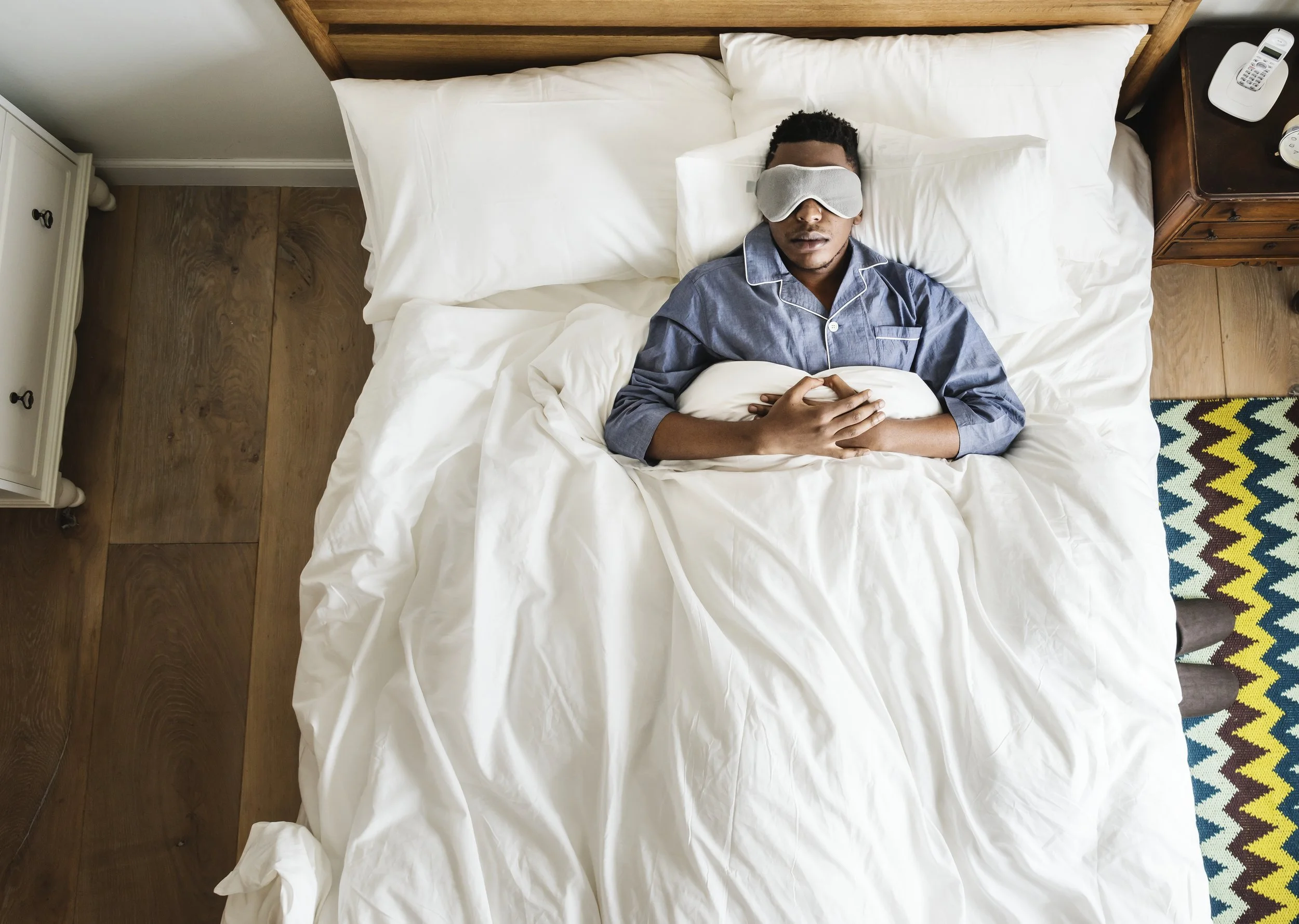 Man sleeps in bed wearing a CPAP mask, receiving nighttime treatment for sleep apnea.