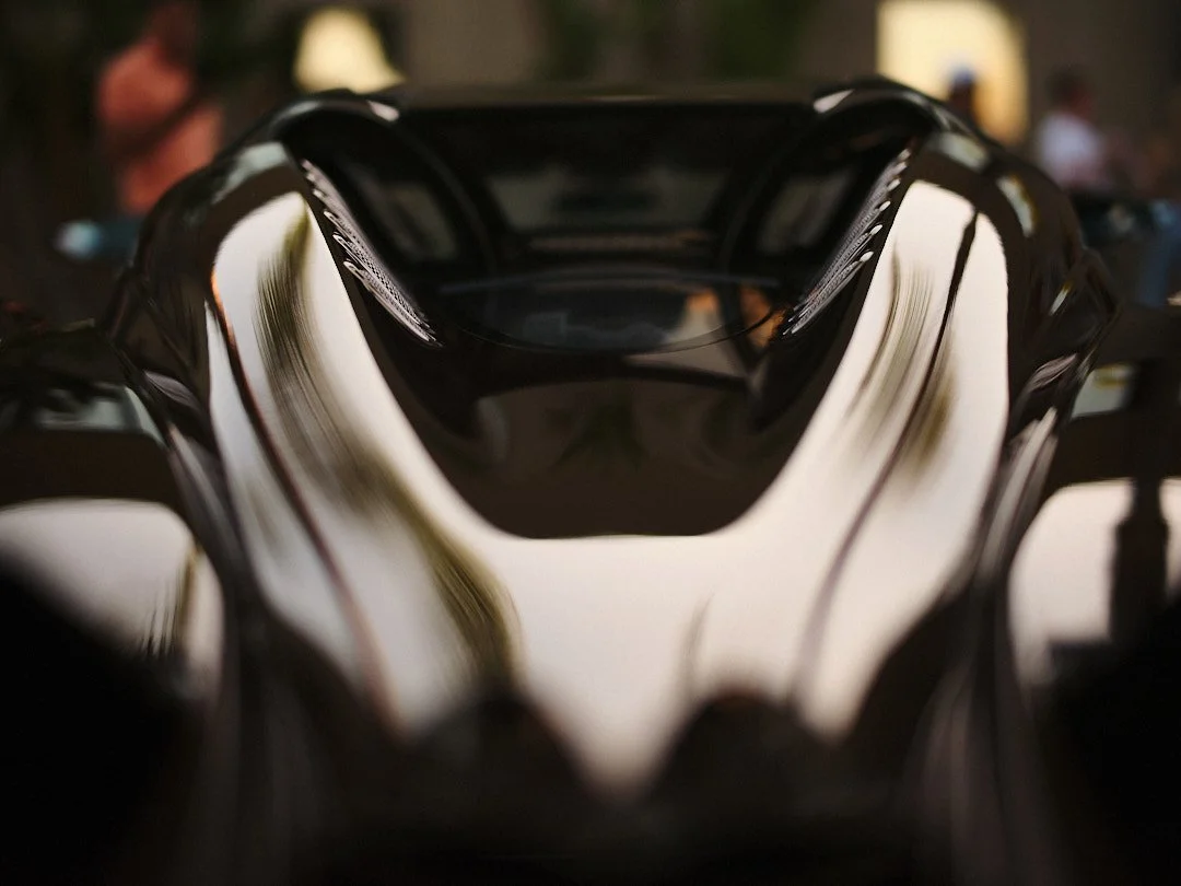 Close-up of a sleek black and white racing helmet on display at an indoor event.