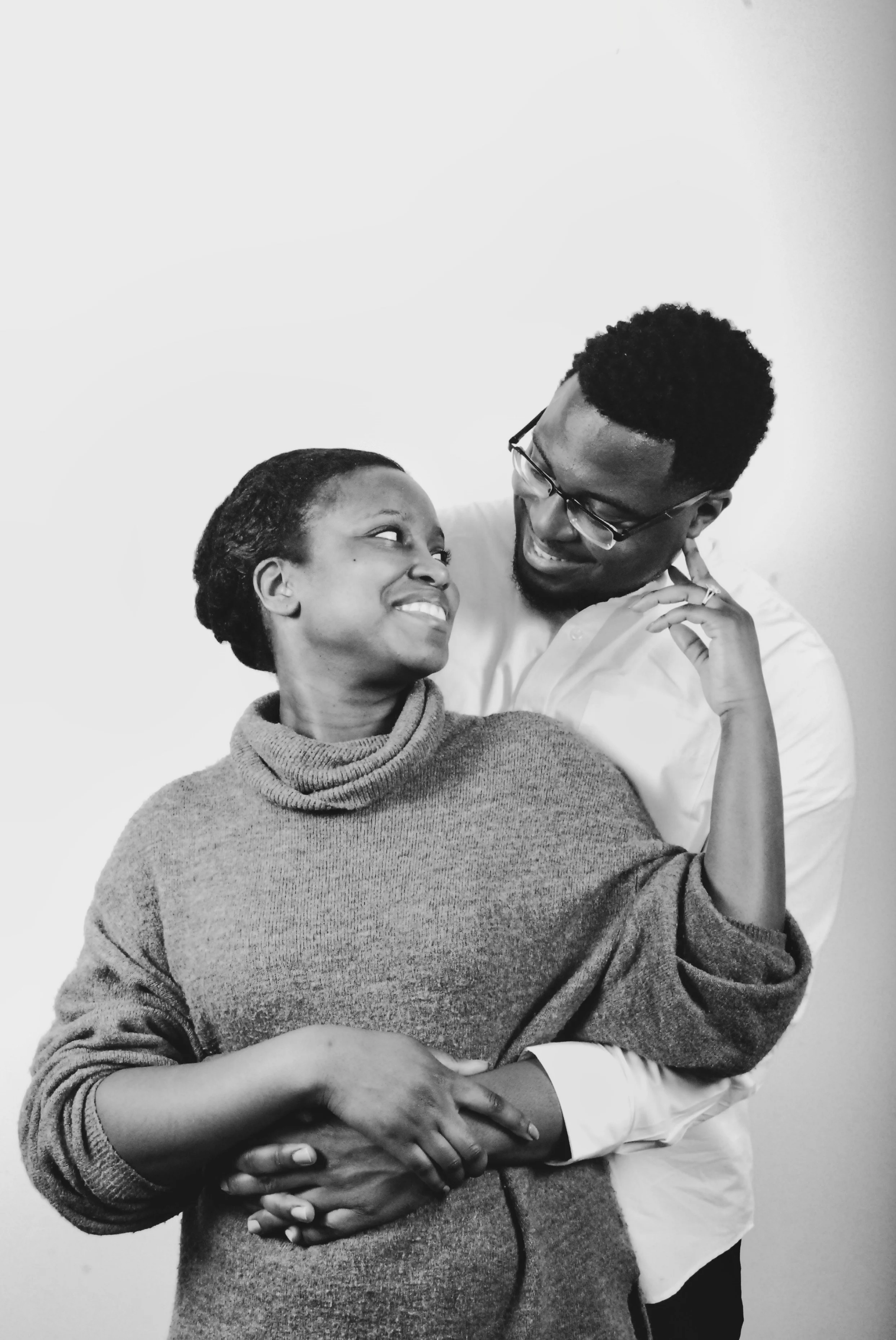 A smiling woman and man embrace, looking at each other affectionately.