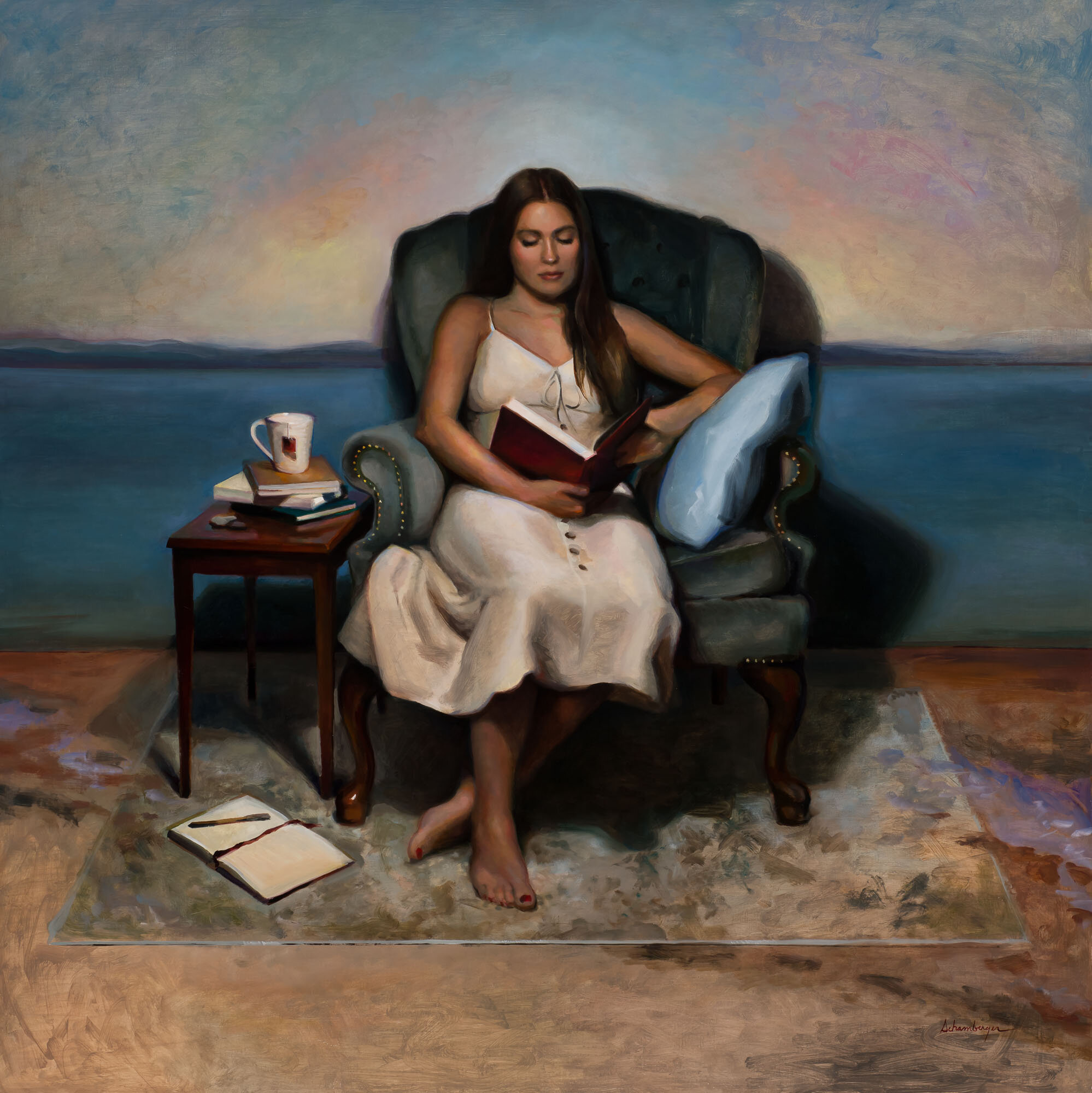A woman in a white dress sitting barefoot on a rug, reading a book in a vintage armchair. A side table holds a mug and stacks of books, with an open book and a writing pen on the rug. The background features a large painting of a water body and sky a