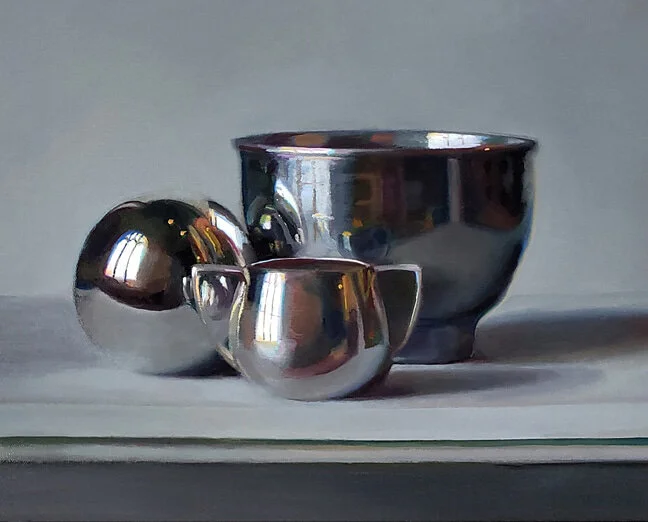 A still life painting of reflective silver or metallic objects, including a bowl, a cup, and a spherical object, set on a light surface.