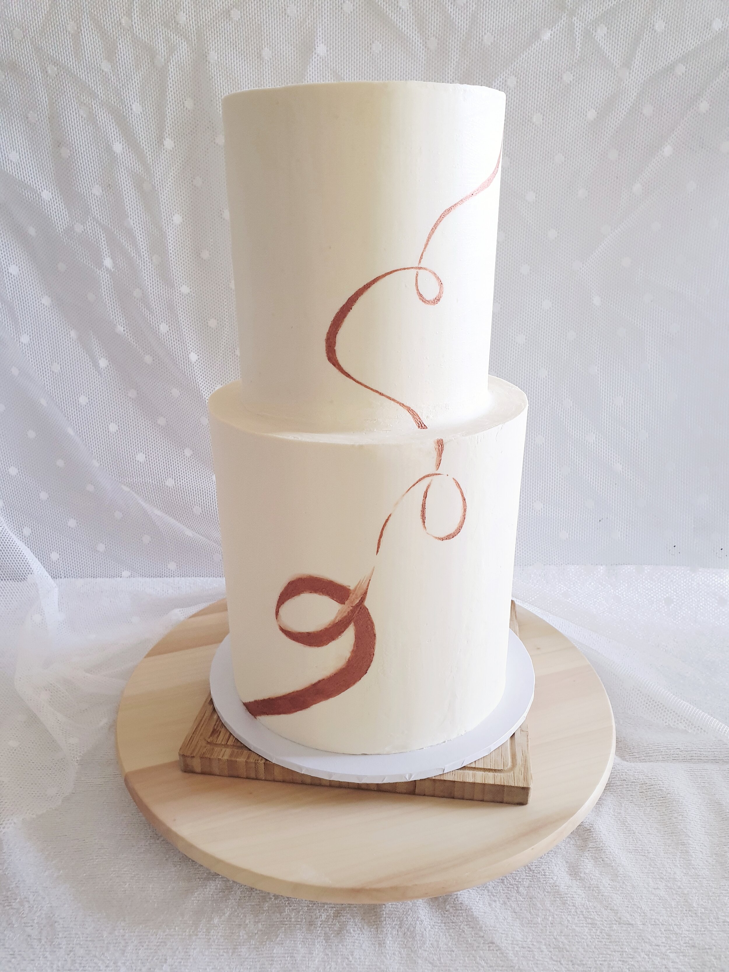 luscious lemon 2 tier engagement cake, with white chocolate ganache coating, decorated with hand-painted rose gold ribbon detail