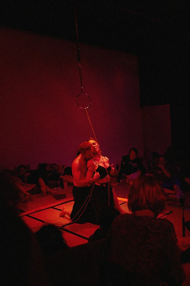 Contemporary Shibari performance by Dan Carabas and Dorcara featuring rope aesthetics, sculptural tension, in a Shibari suspension.