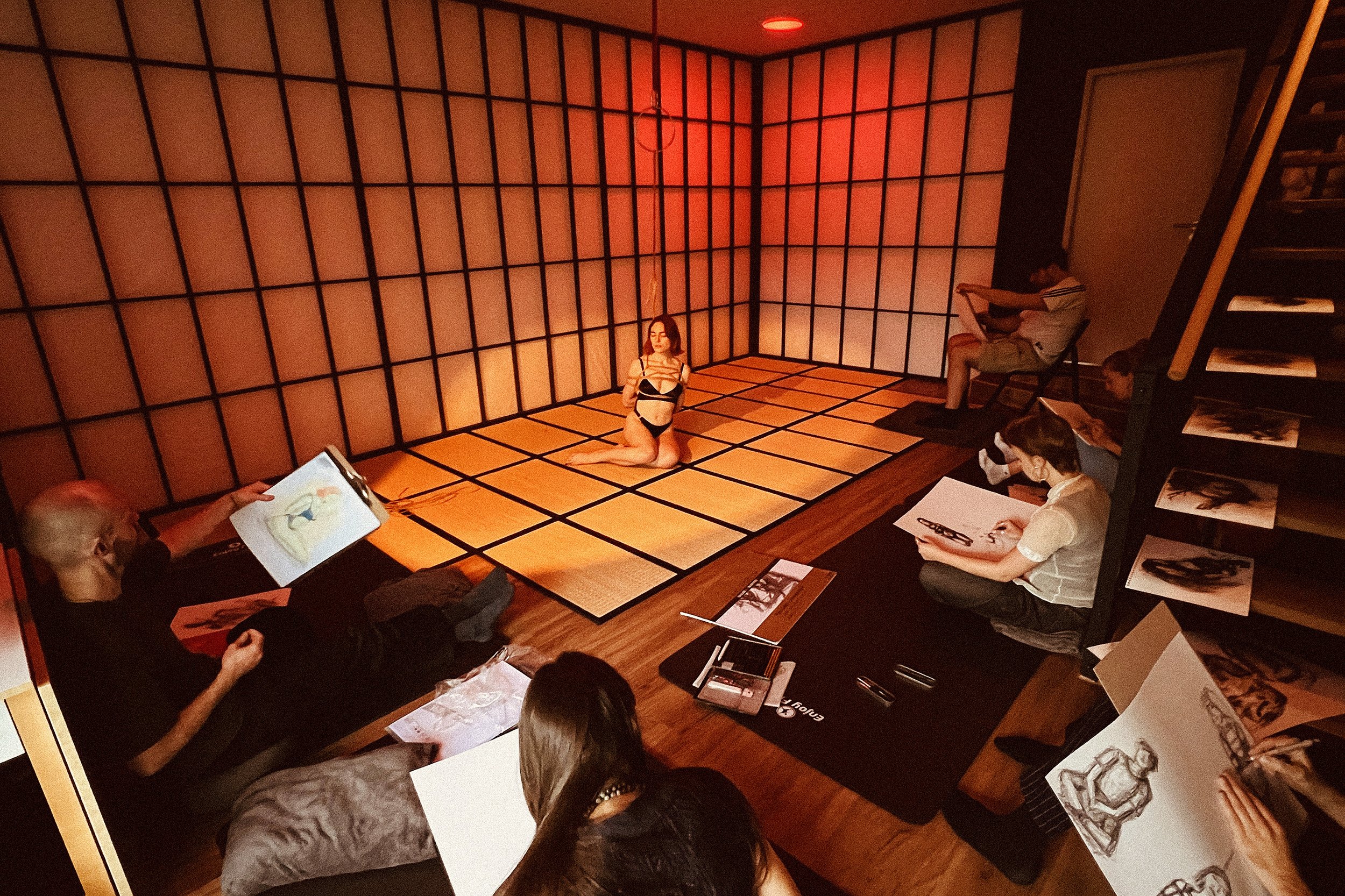 Participants drawing a live Shibari rope scene during an inclusive life drawing workshop led by Dan Carabas and Dorcara.