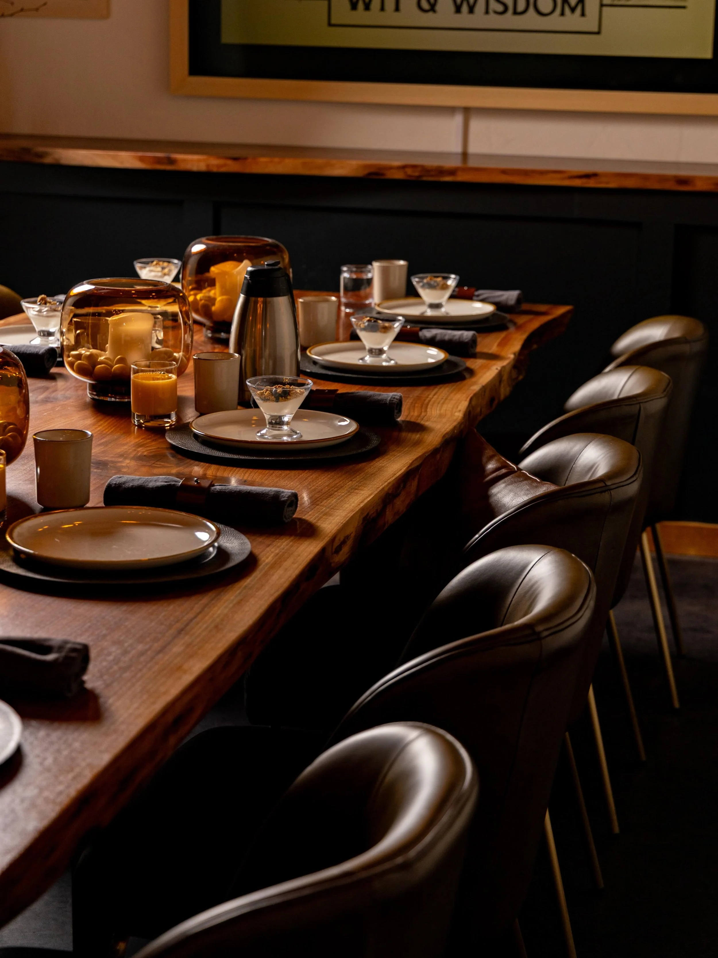 There&rsquo;s a quiet kind of luxury in a table made by hand. This one &mdash; a single live-edge slab from a maker just down the road &mdash; sets the tone for the whole room. Soft leather. Amber glass. Candlelight catching the grain of the wood.

W