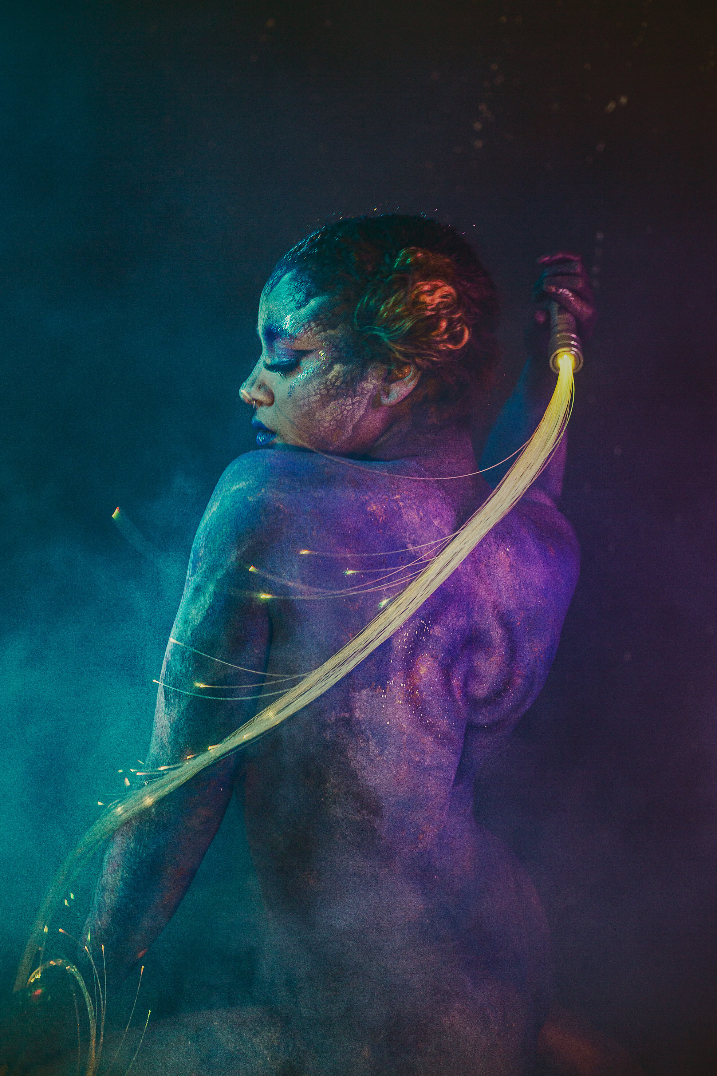 bipoc woman in galaxy body paint with LED light whip