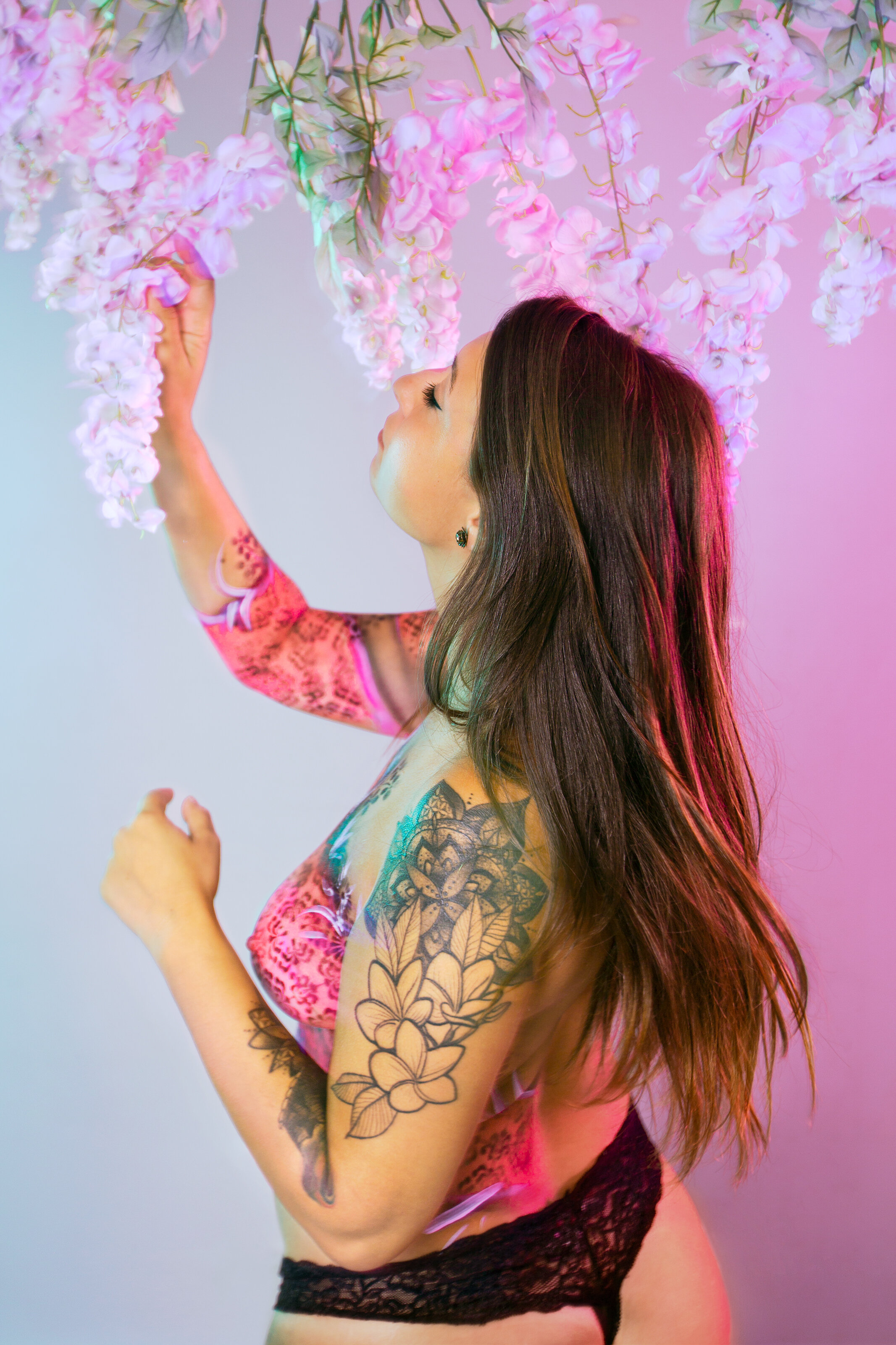 woman with neon pink bodypaint plays with flowers boudoir studio floral photography