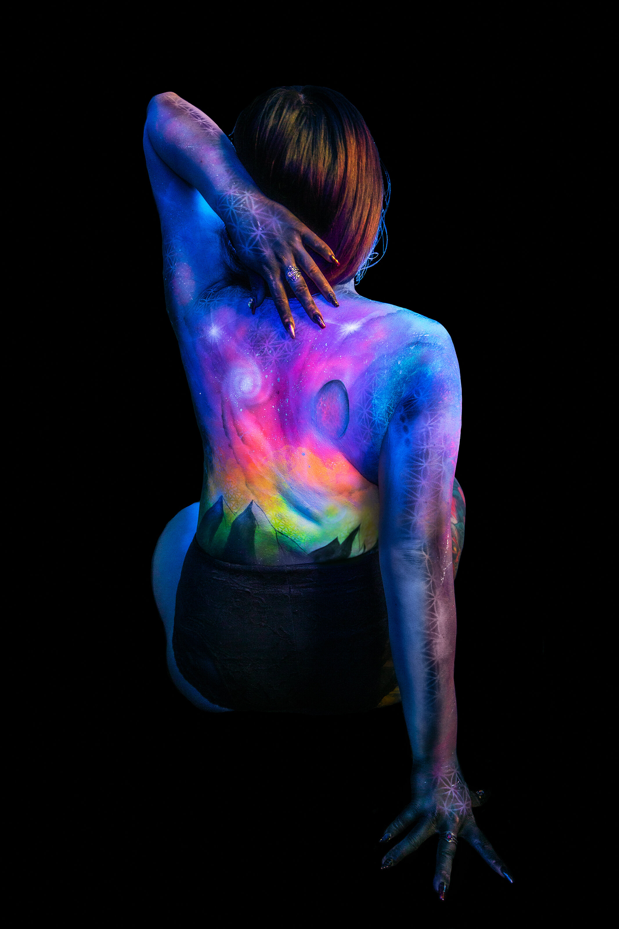 woman starry galaxy bodypaint art with blacklight neon glowing planets