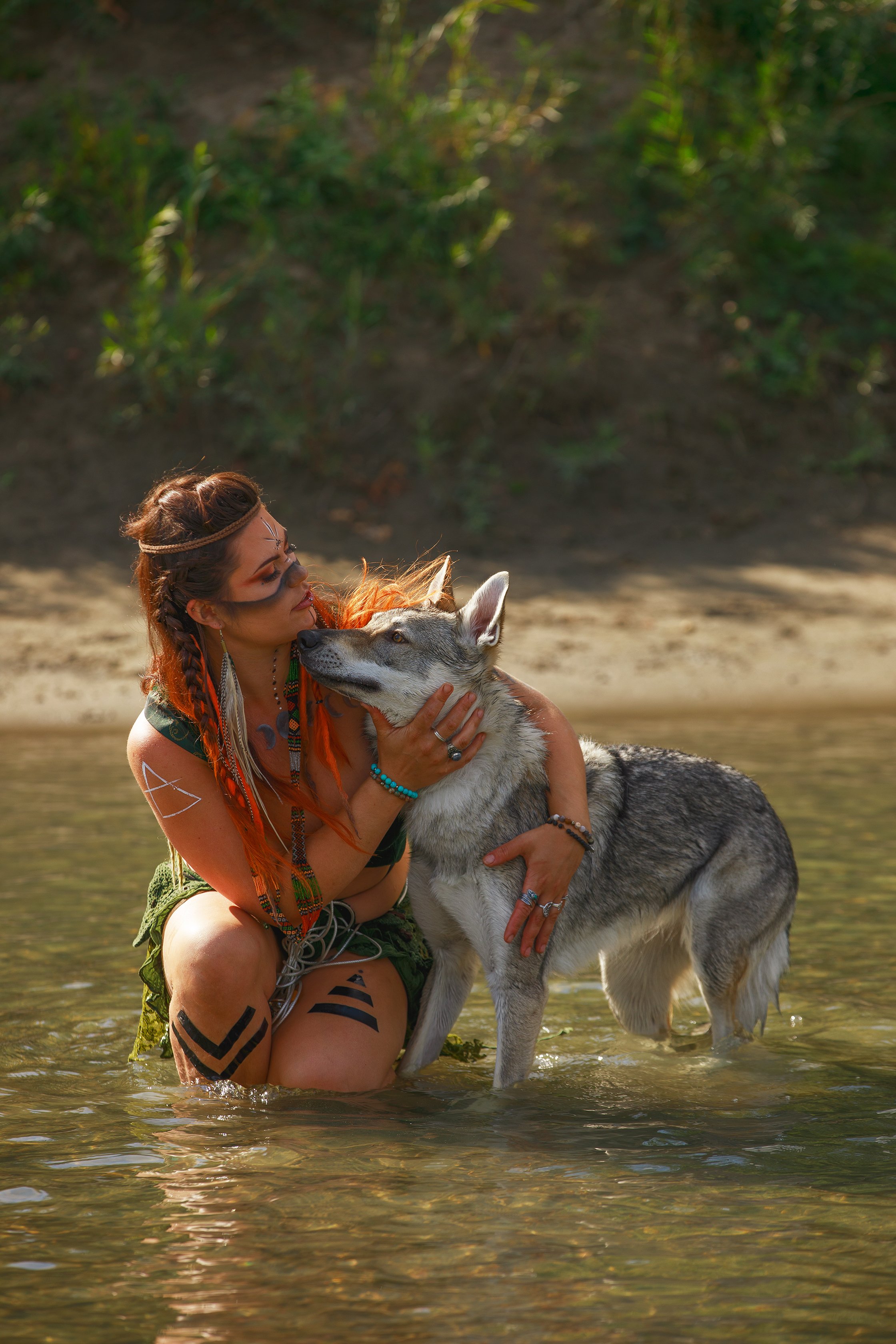 edmonton bipoc metis portrait photographer woman with wolf playing in water
