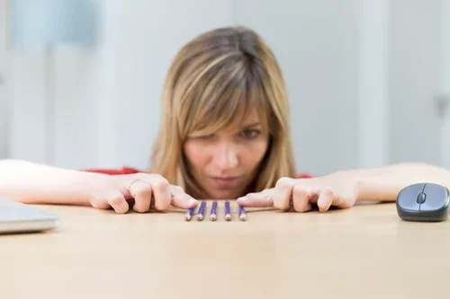 Woman concentrating on her hands resting on a desk, for OCD therapy in Perth