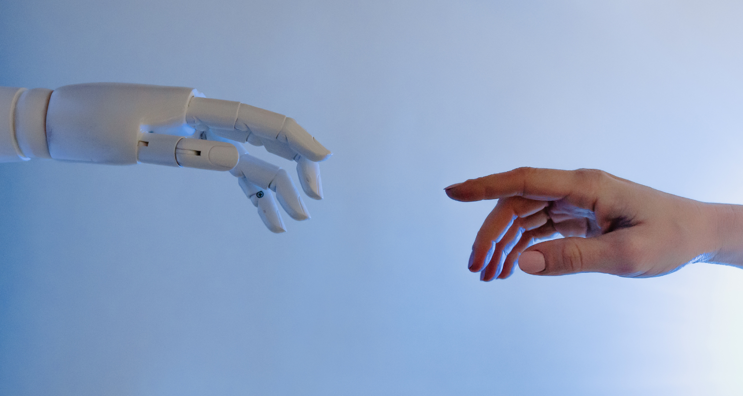 A human hand reaching out towards a robotic hand, pointing to AI guides and resources to help people learn ai filled with great AI tips