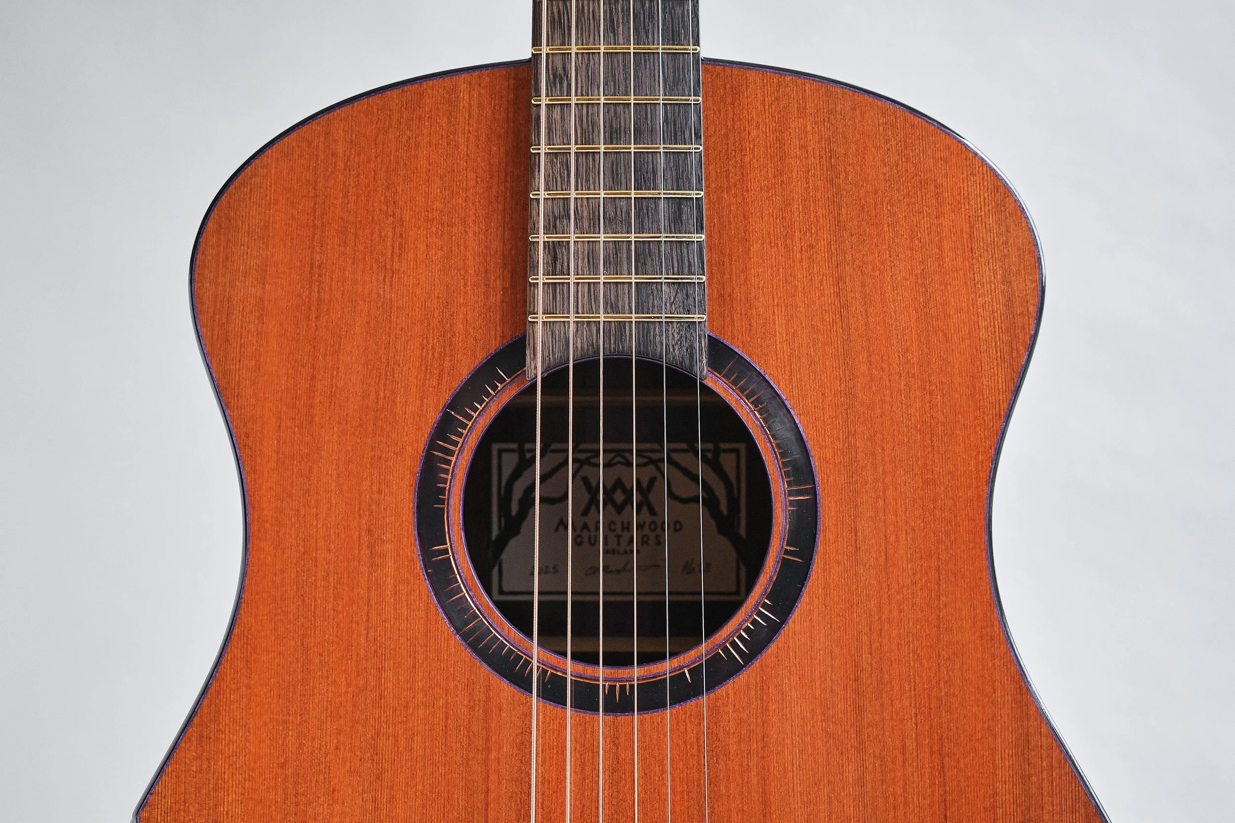 2025 OM 13 fret short scale in Lost tunnel redwood and bog oak. Featuring a hand engraved 'eclipse' rosette, slotted headstock and mini arm bevel. 