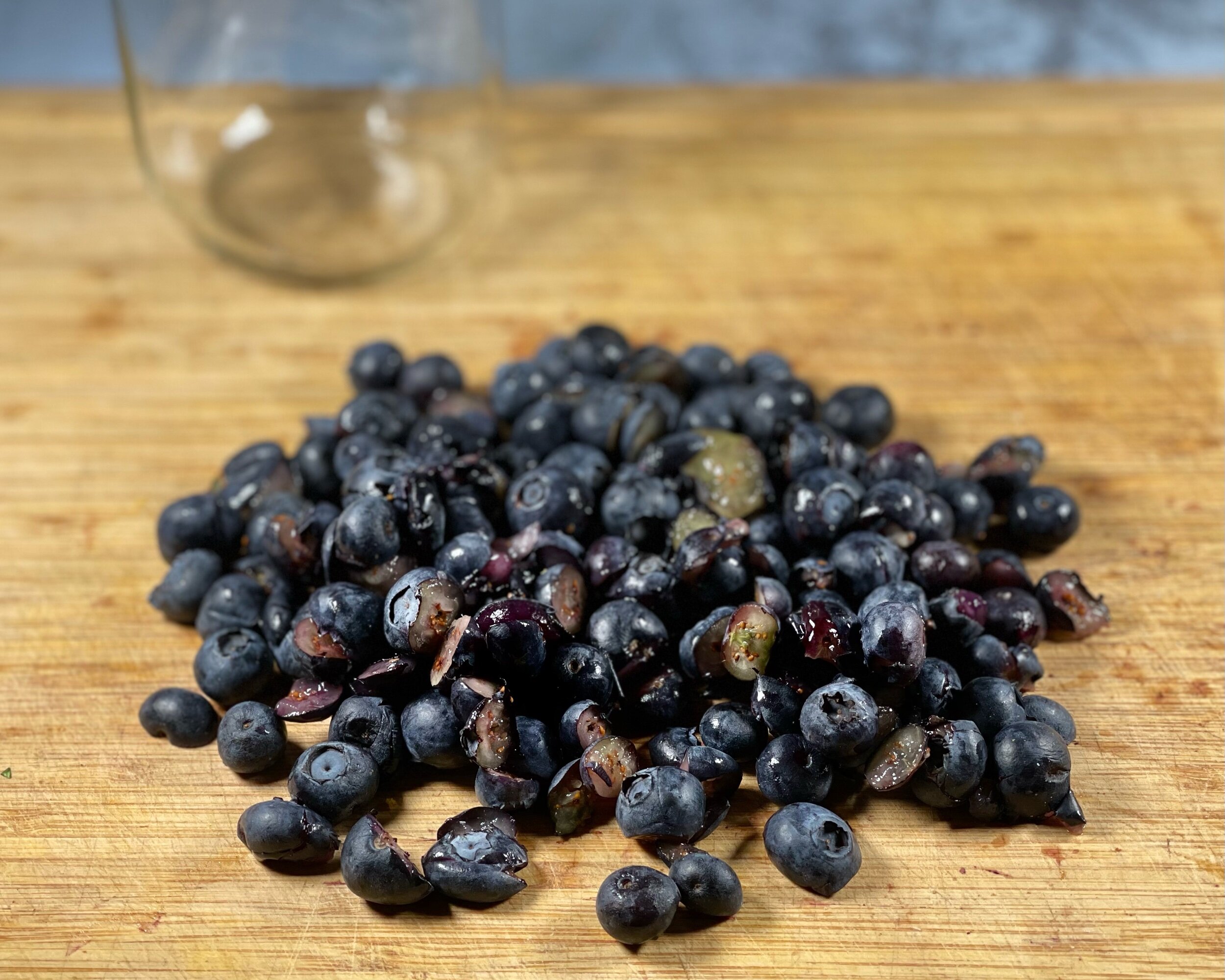  Lightly chopped/smashed blueberries on a cutting board 