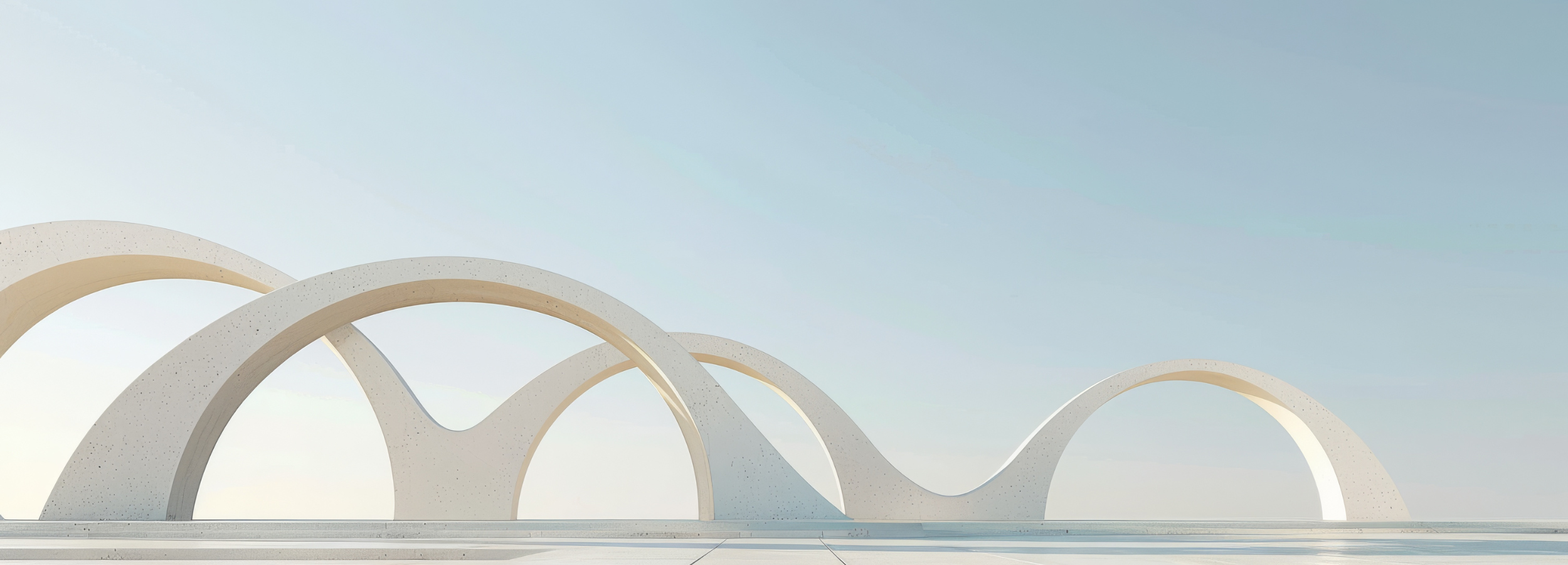A modern architectural image featuring white arches with a smooth, curved design against a clear sky.
