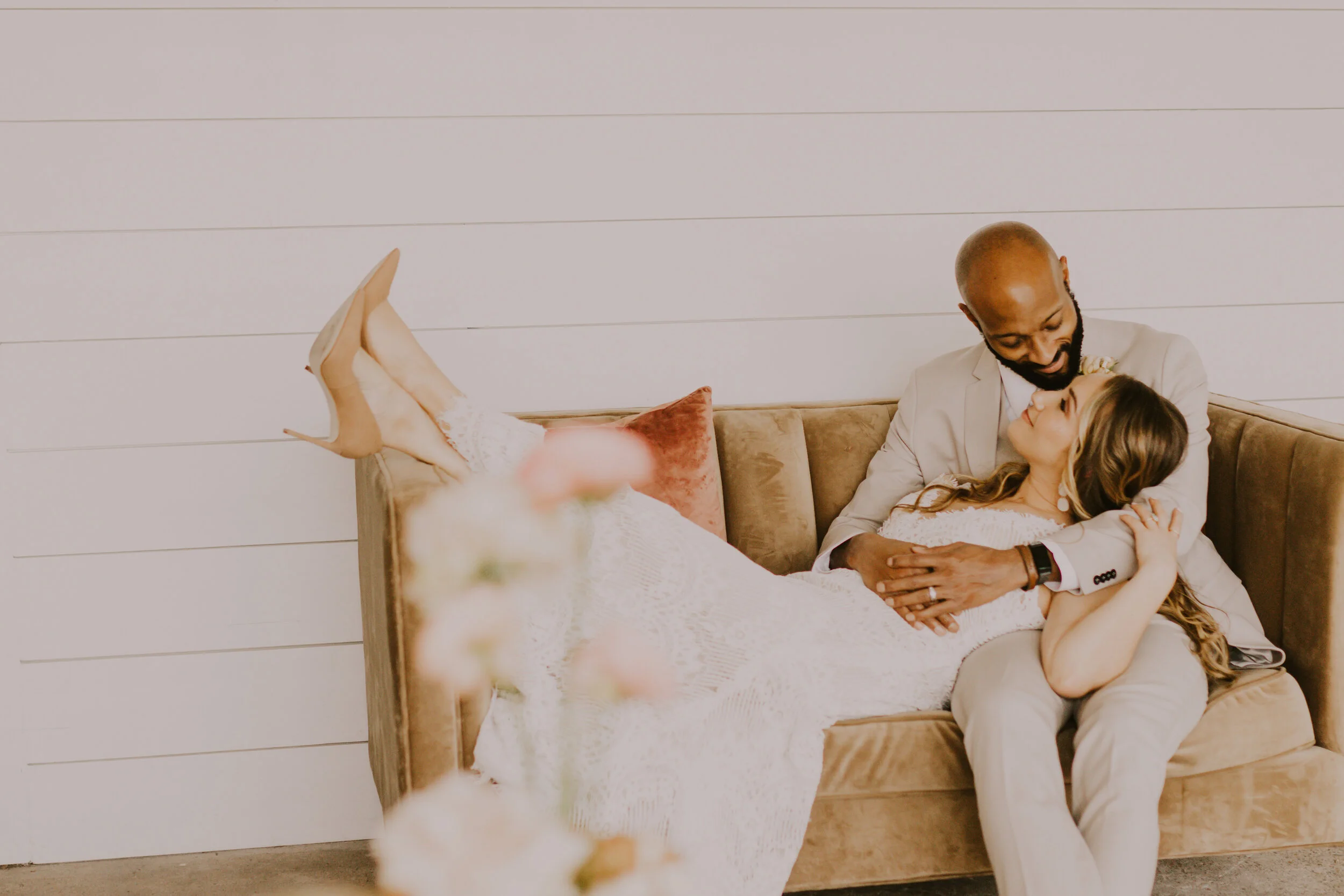  Bride and Groom pose relaxed together during a stunning boho inspired wedding styled shoot in Denver, Colorado with Dawn Louise Photography. Bride and groom wedding day details orange heels neutral colors white lace dress tan groom suit denver weddi