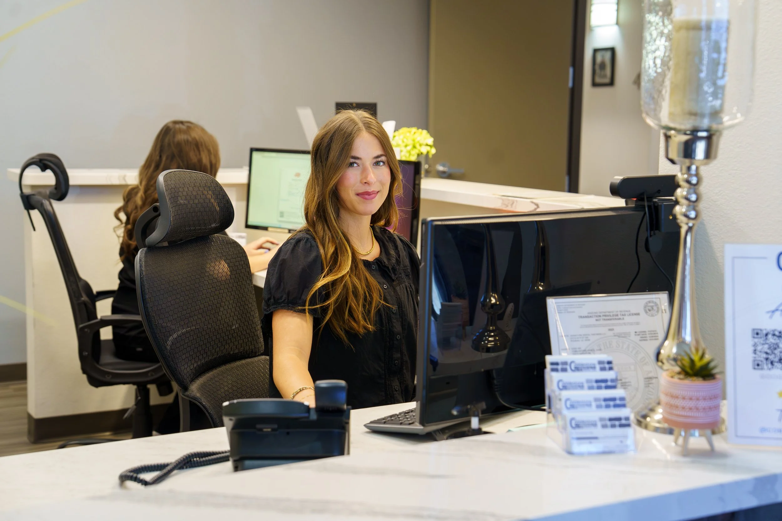 Dental office employee photographed at the reception desk during a corporate photography session in Gilbert, Arizona