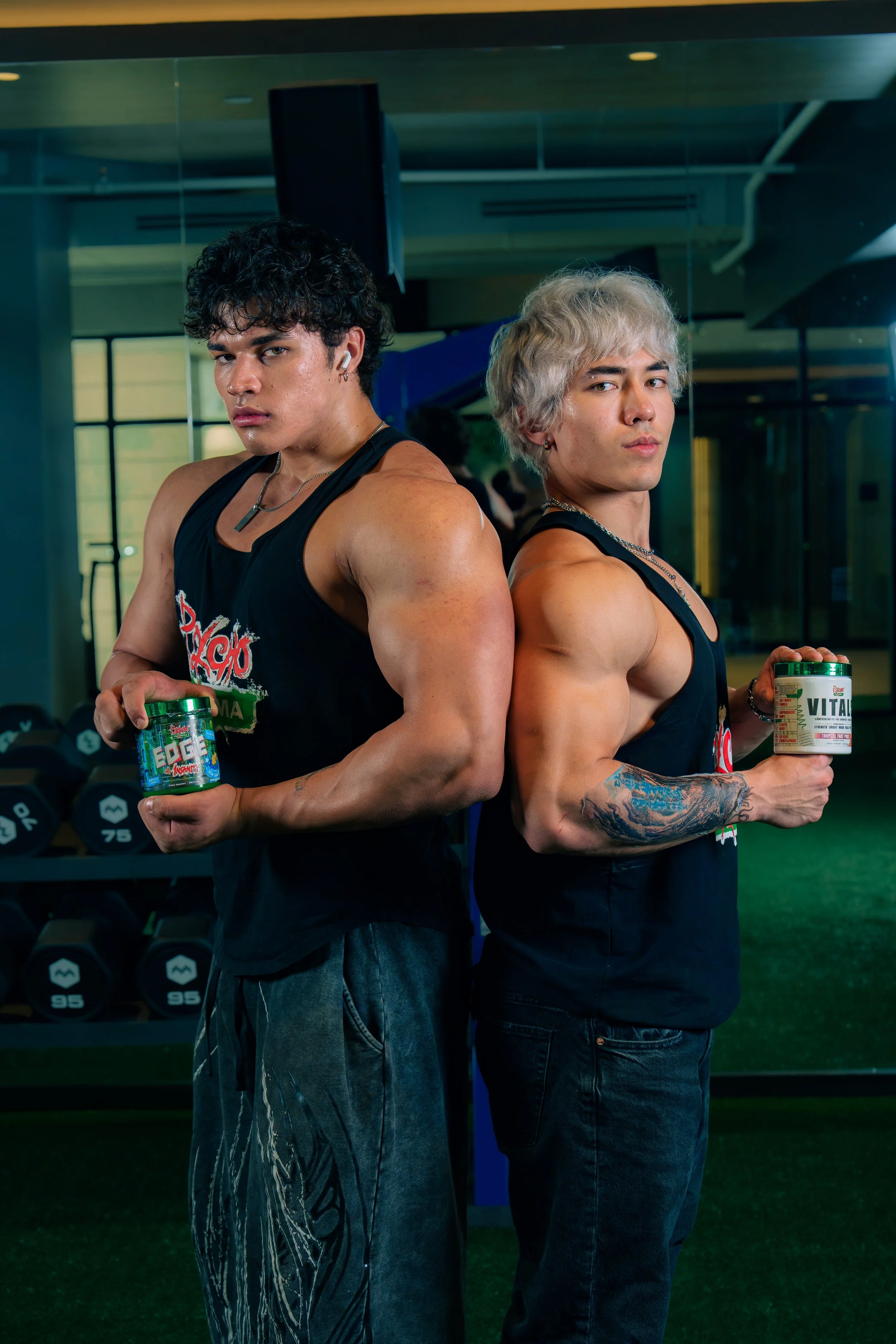 Two Psycho Pharma athletes posing back to back with supplements during a Phoenix fitness campaign
