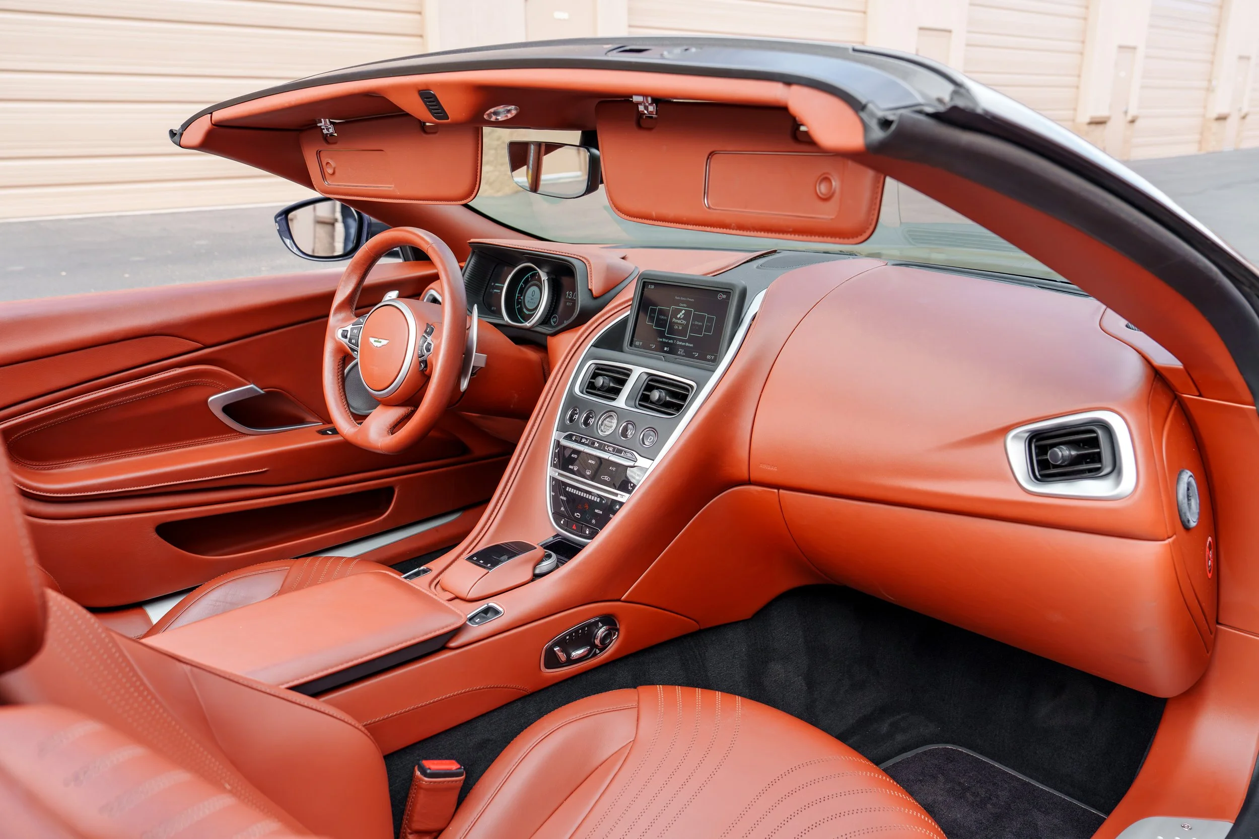 Angled view of the leather dashboard and passenger compartment of an Aston Martin DB11 Volante