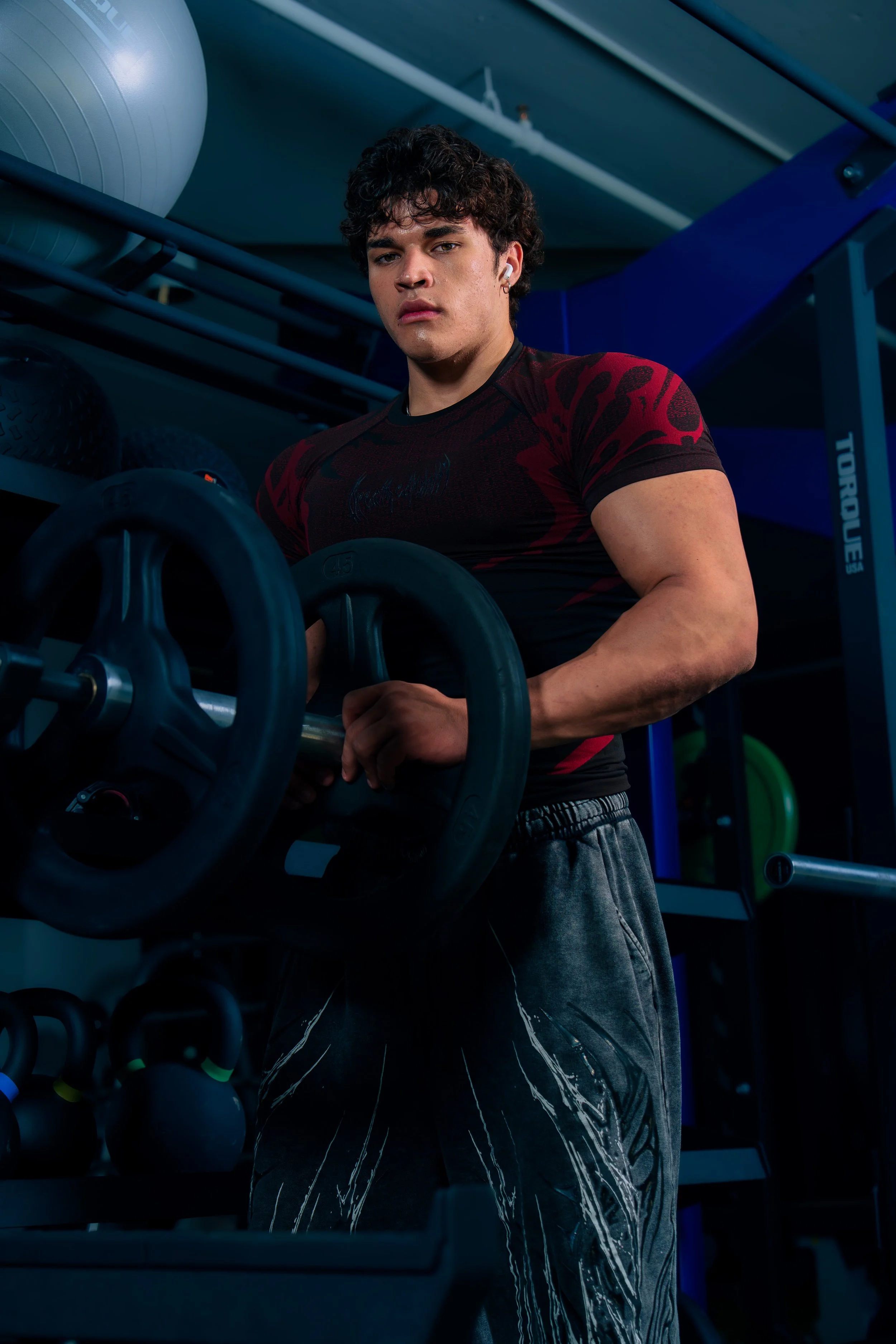 Fitness athlete holding a supplement during a commercial lifestyle photoshoot in a Phoenix gym