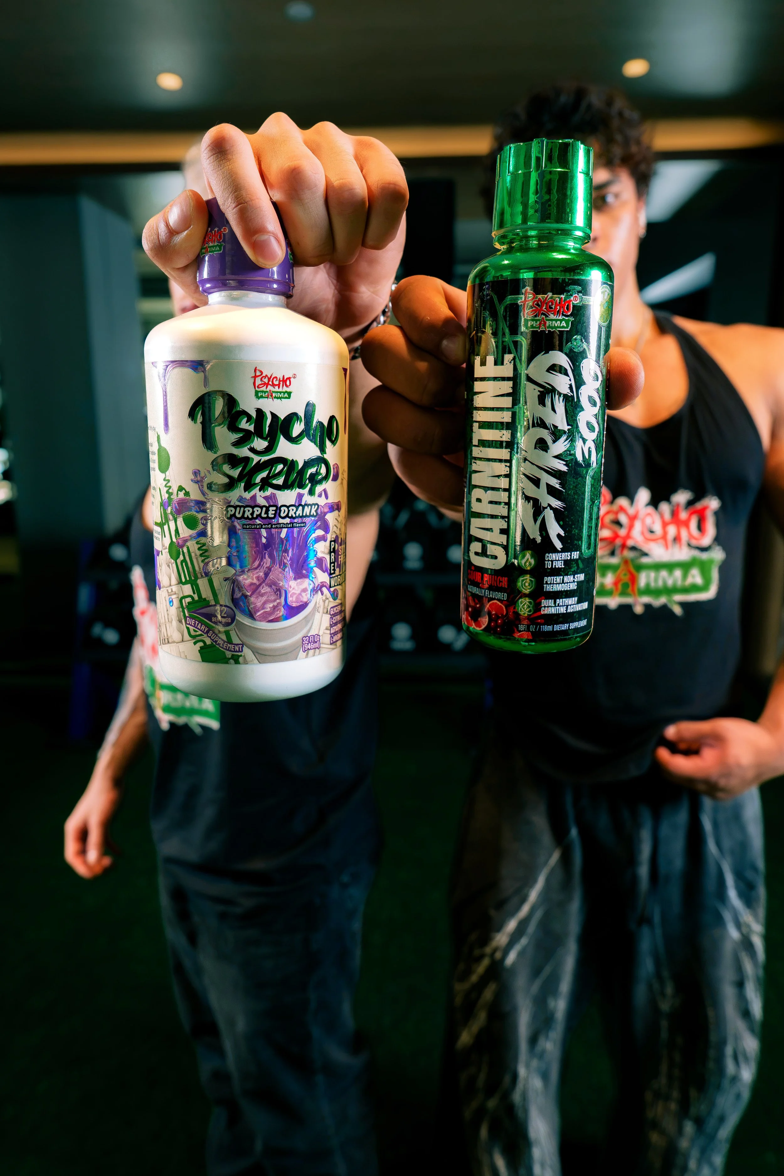 Alt text: Psycho Pharma supplements held toward the camera by fitness athletes in a Phoenix gym