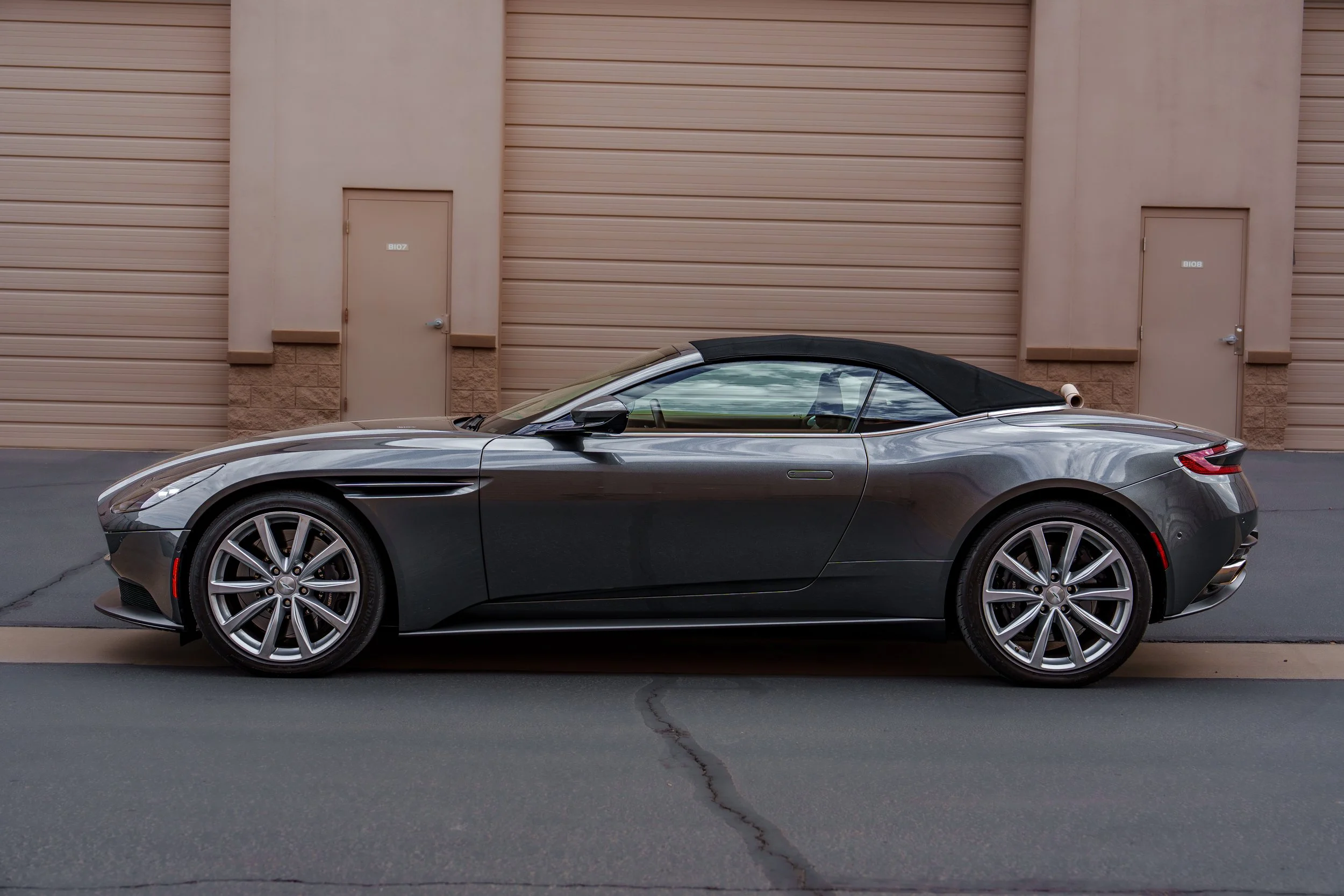 Side profile of a 2020 Aston Martin DB11 Volante with the convertible roof raised