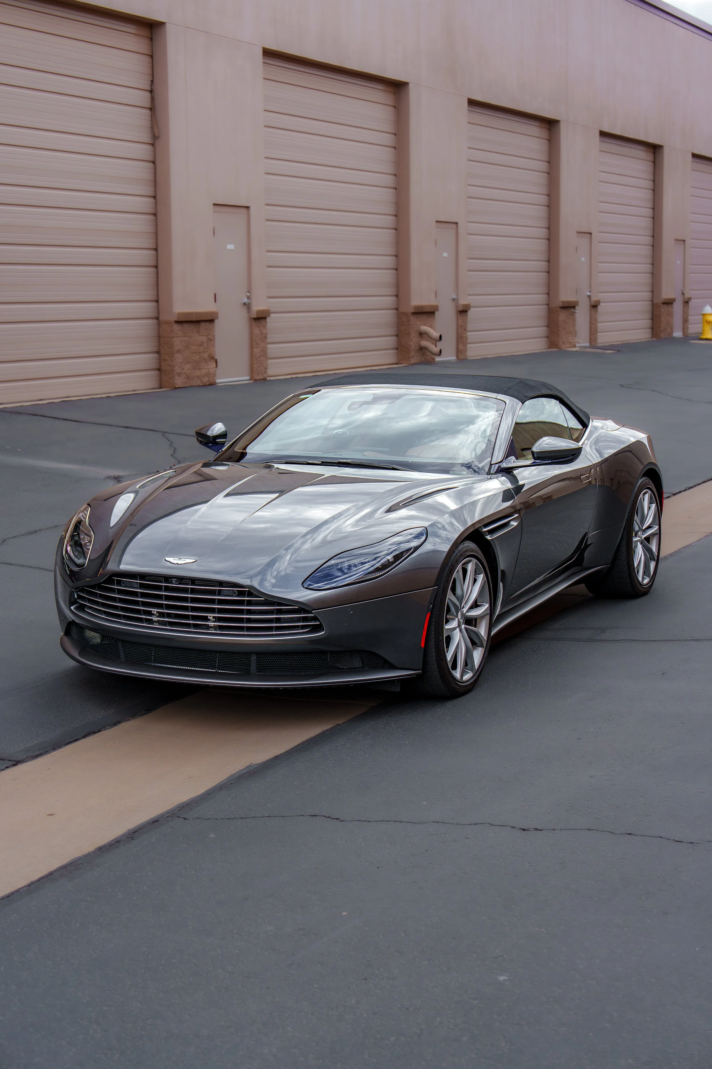 Front three-quarter view of a gray Aston Martin DB11 Volante photographed in Cave Creek
